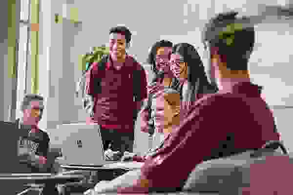 students gathered around a laptop