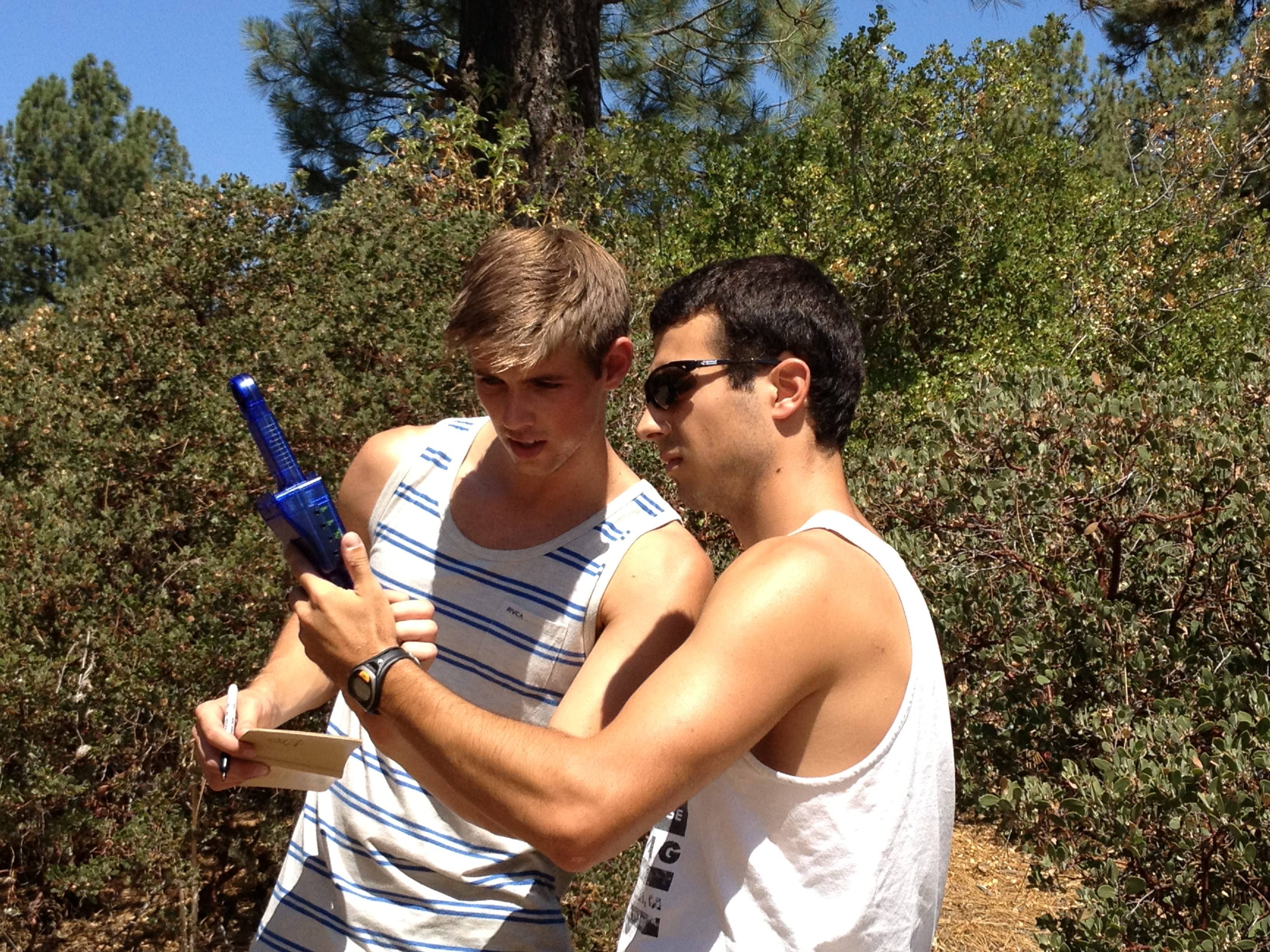 a person holding a blue toy gun next to another person