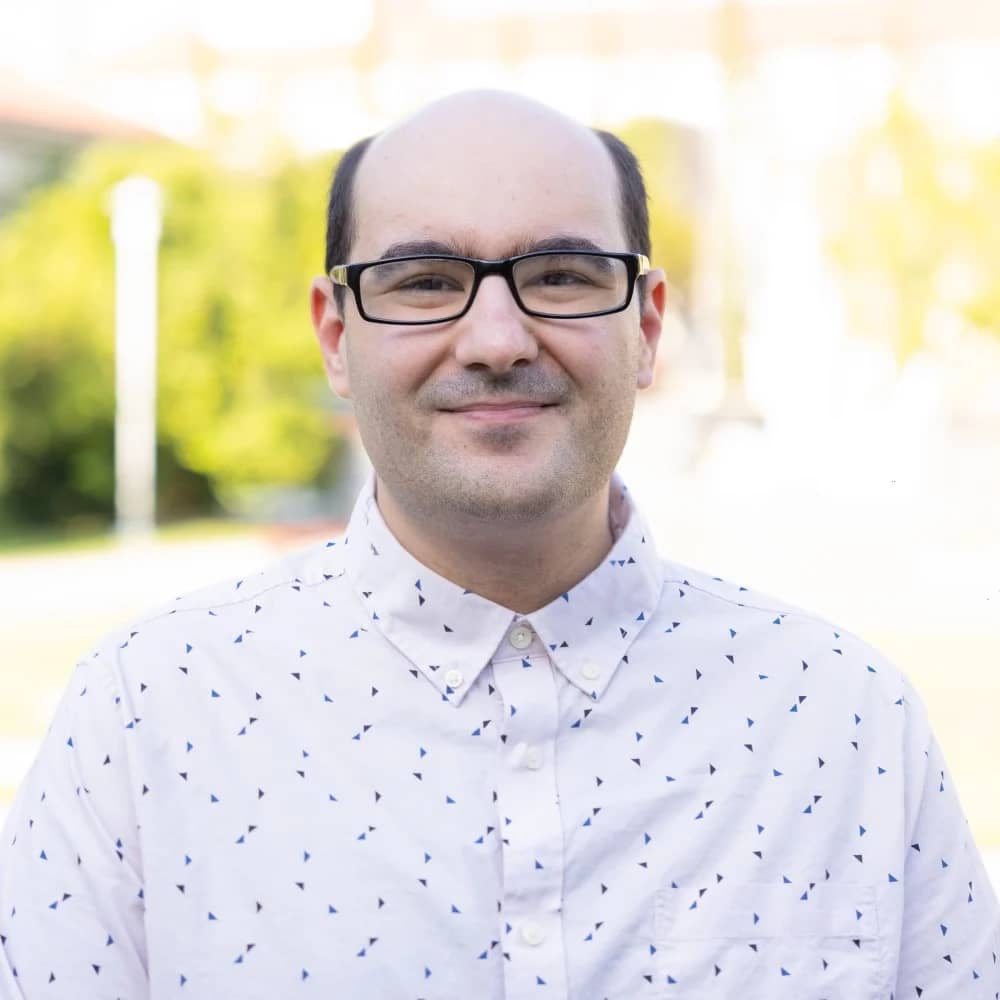 a person wearing glasses and a white shirt