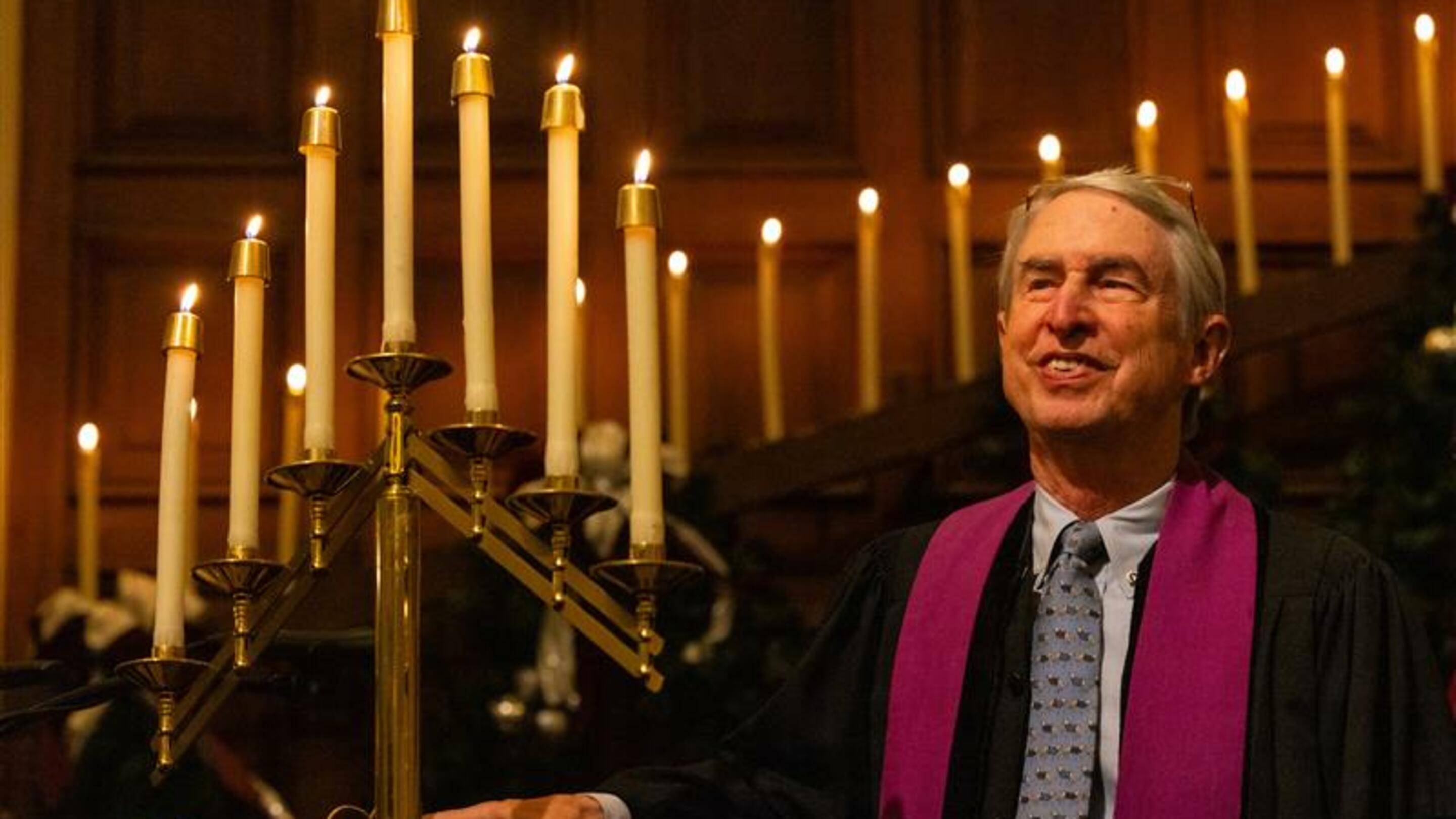 a person in a robe and tie with a large candelabra