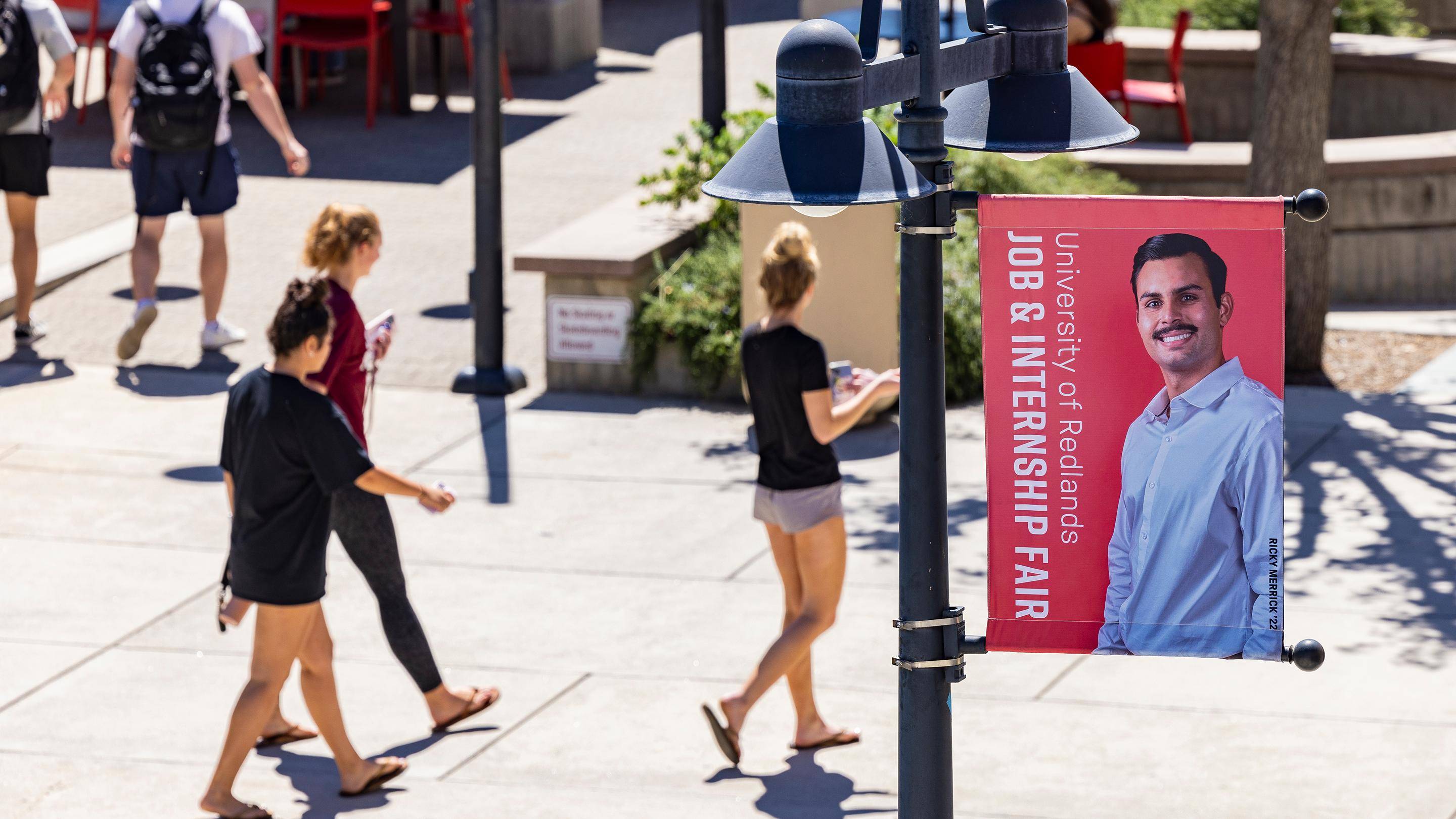 a group of people walking on a sidewalk