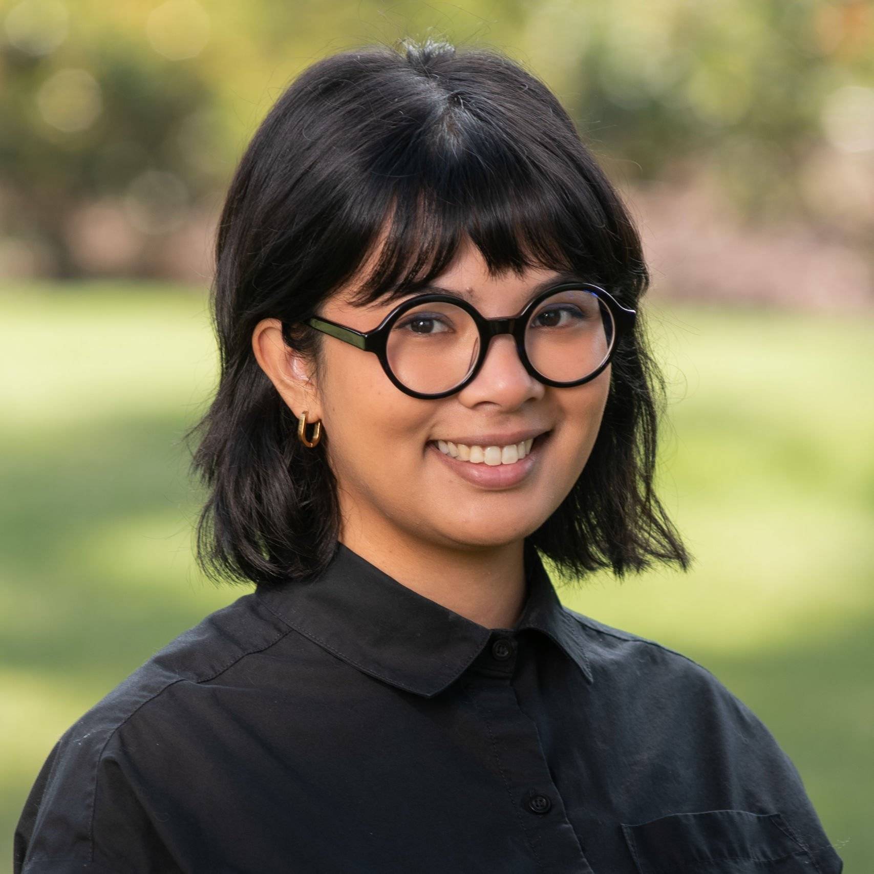 a person wearing glasses and smiling