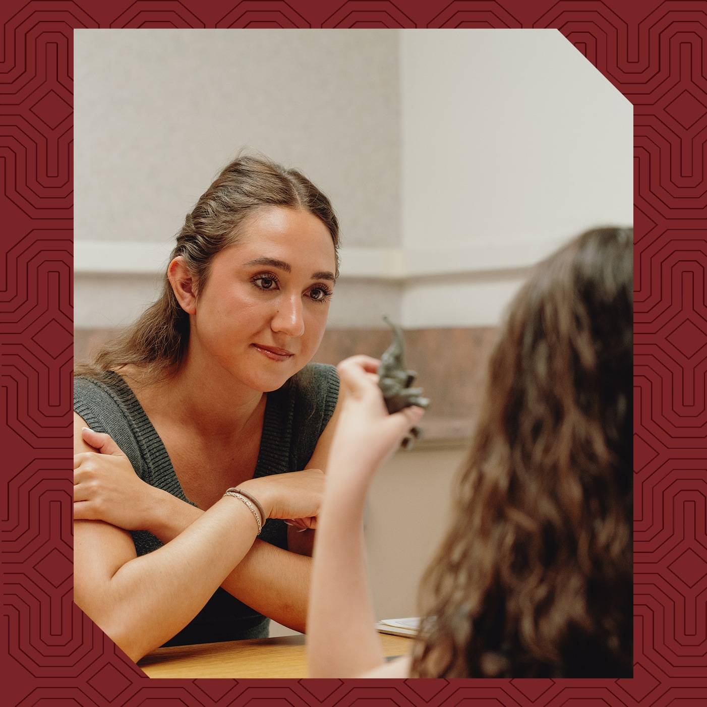 a person sitting at a table with her arms crossed