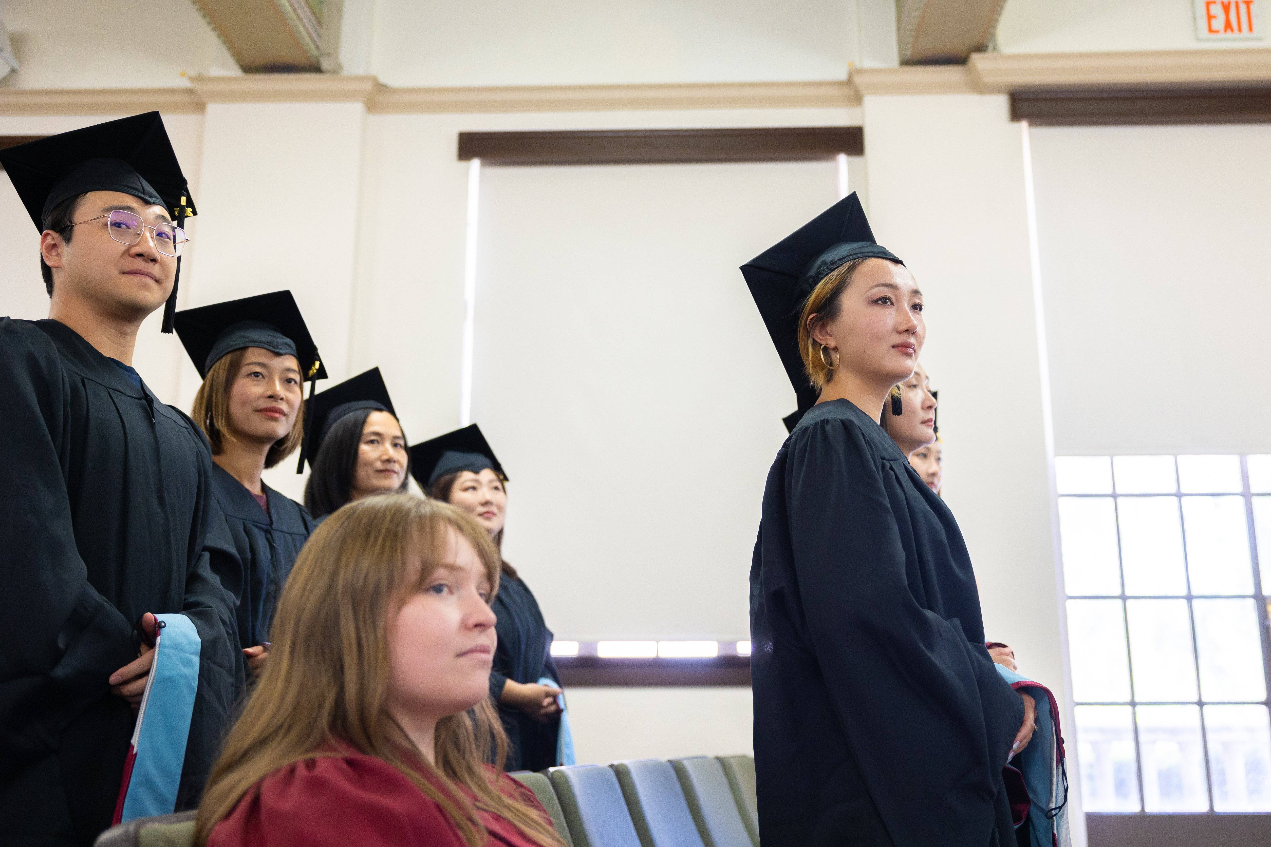a group of women in graduation gowns and caps