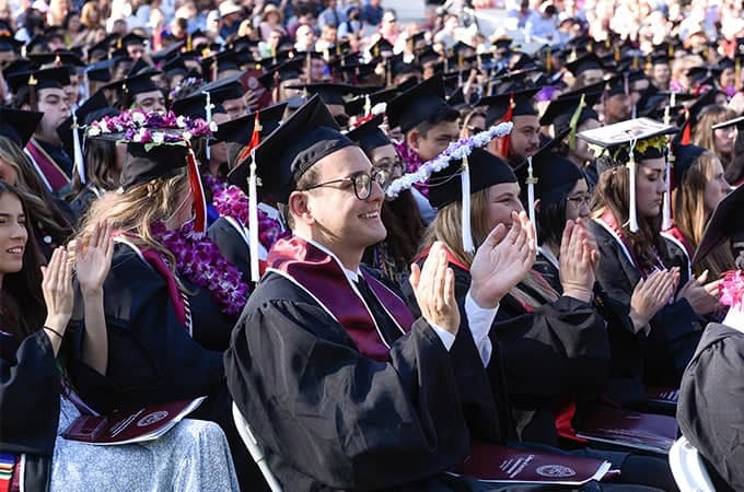 a group of people in graduation gowns and caps