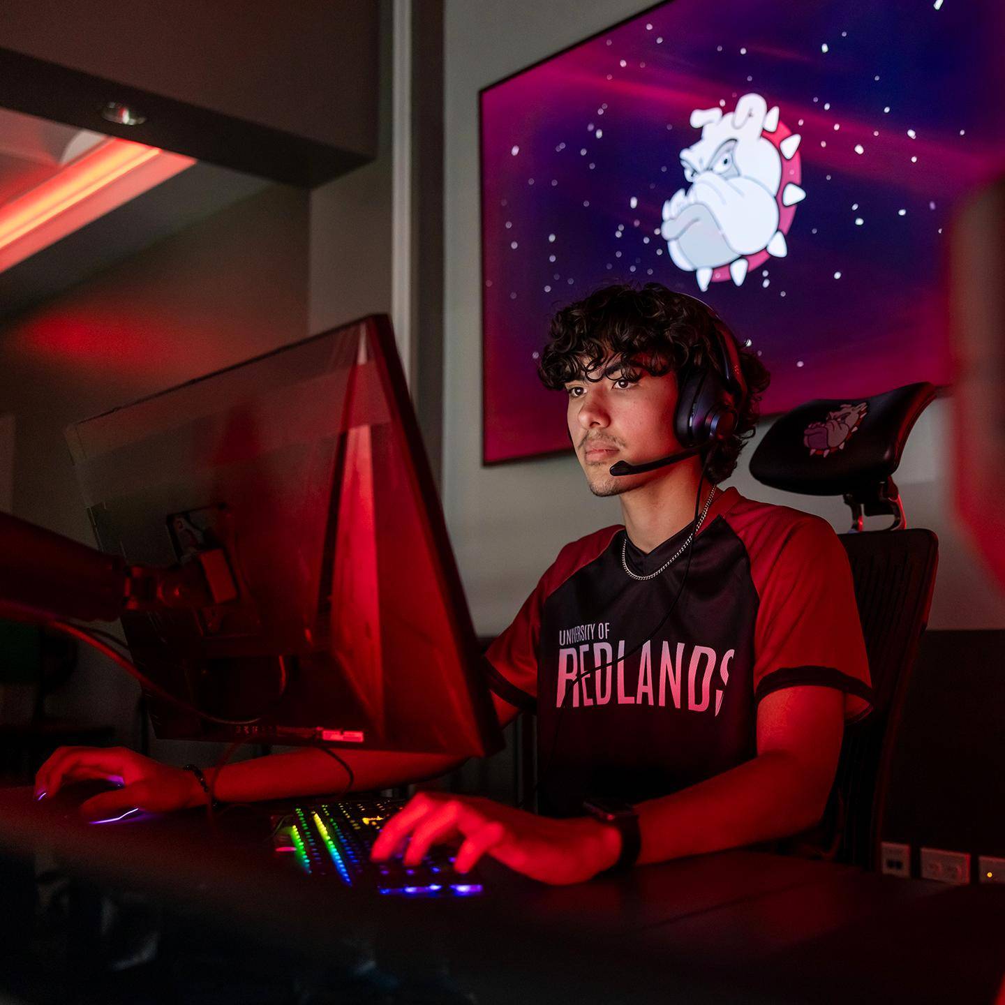 a person sitting at a computer with a headset on