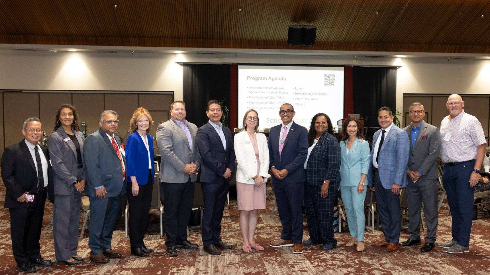 a group of people standing in front of a screen