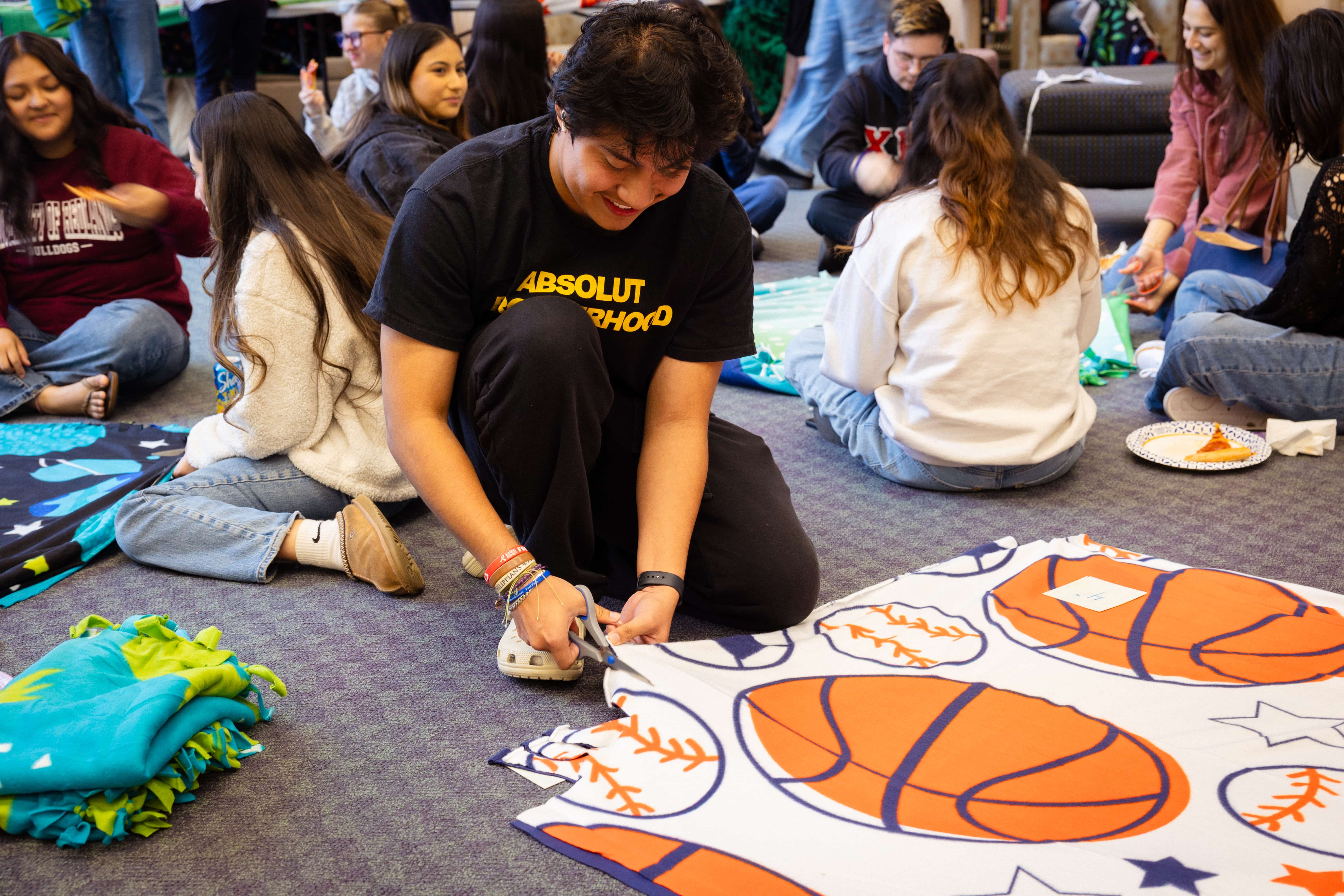 a person cutting a blanket with scissors