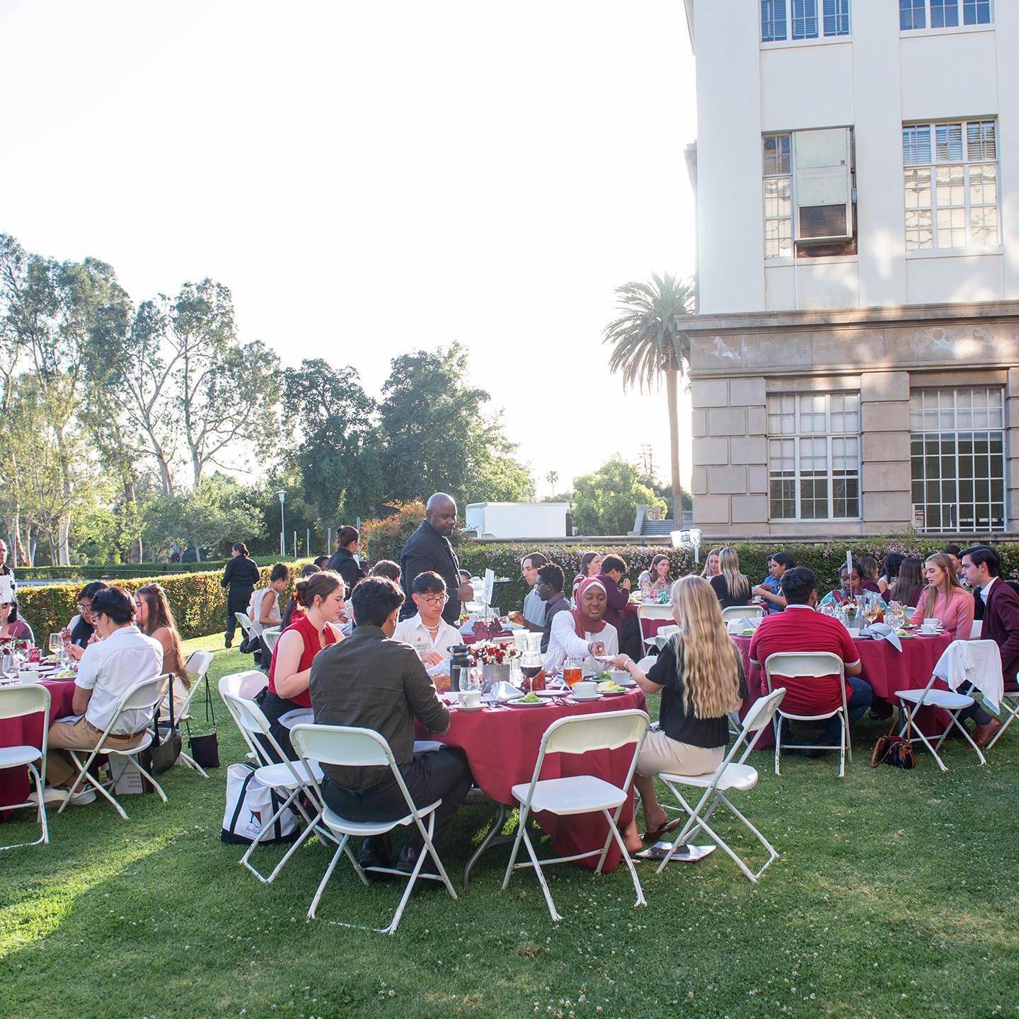 a group of people sitting around tables outside