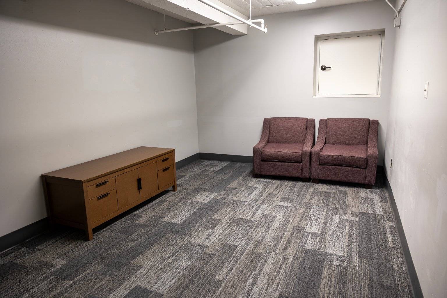 a room with two chairs and a cabinet