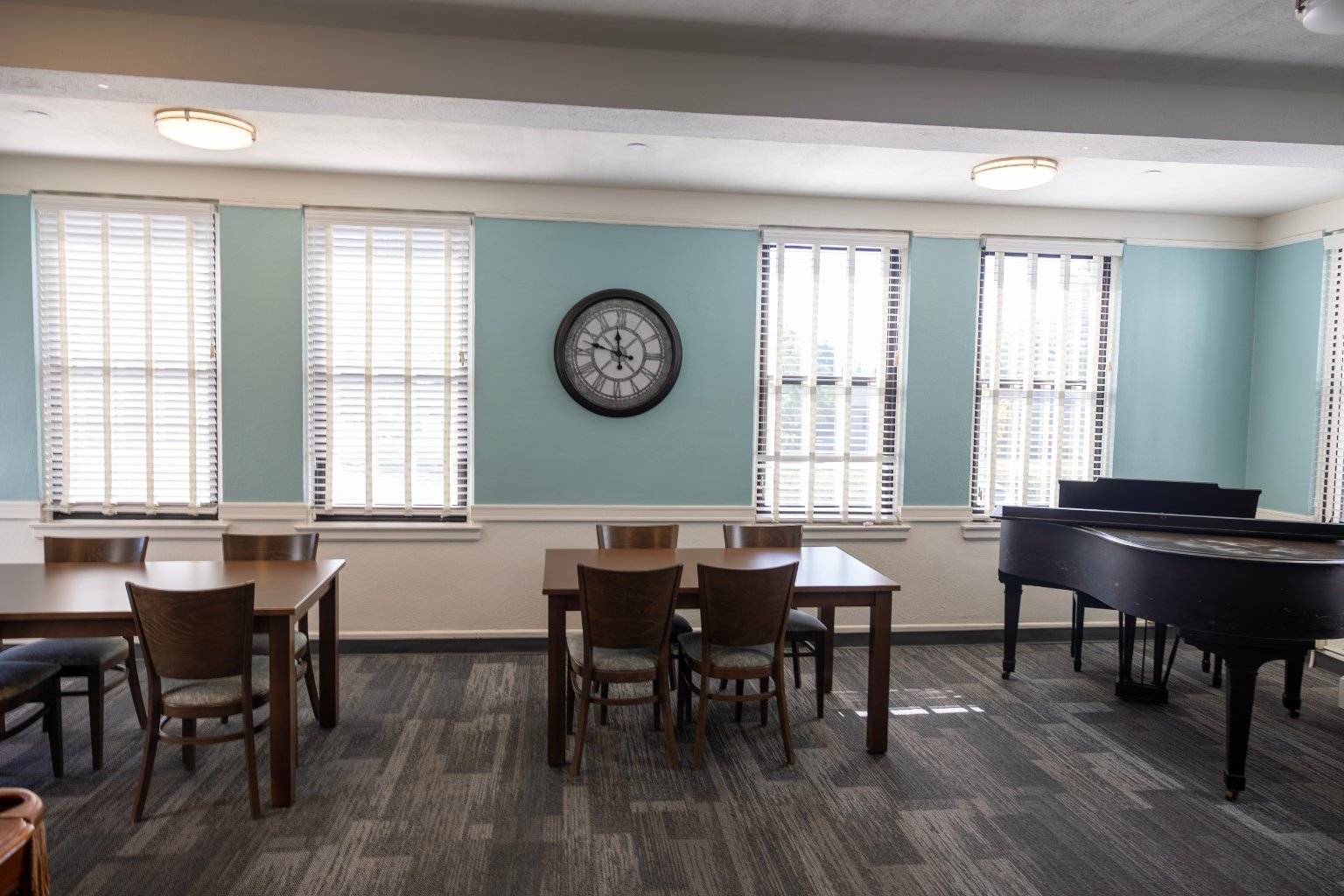 a room with a piano and chairs