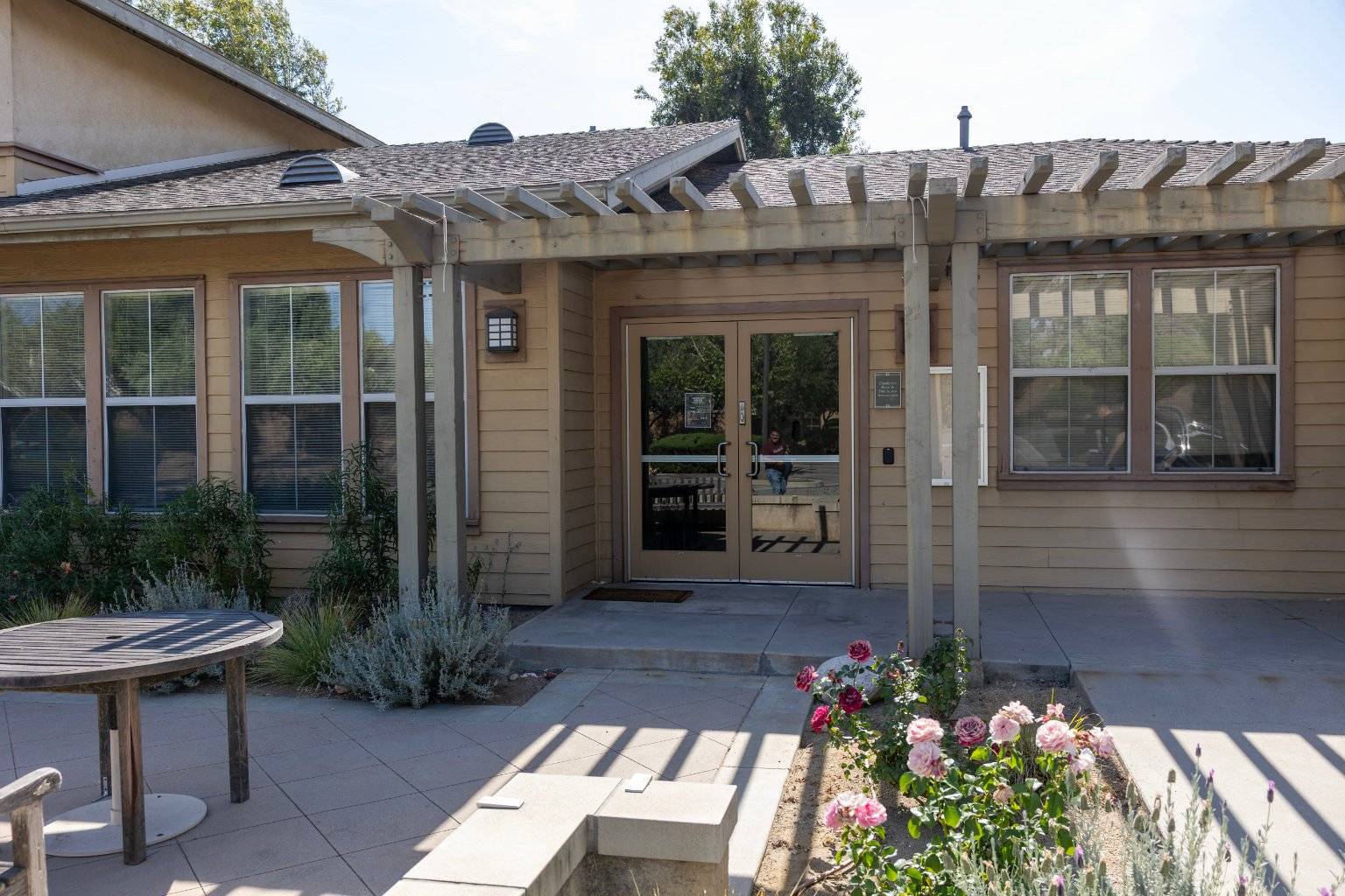a house with a pergola and flowers