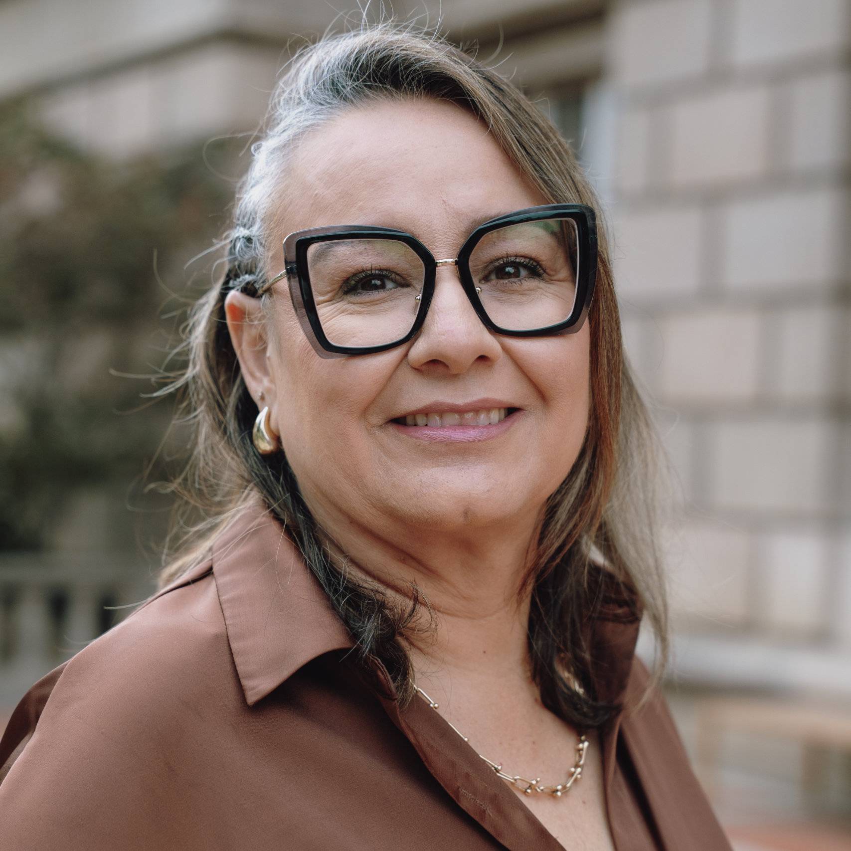 a person wearing glasses and smiling