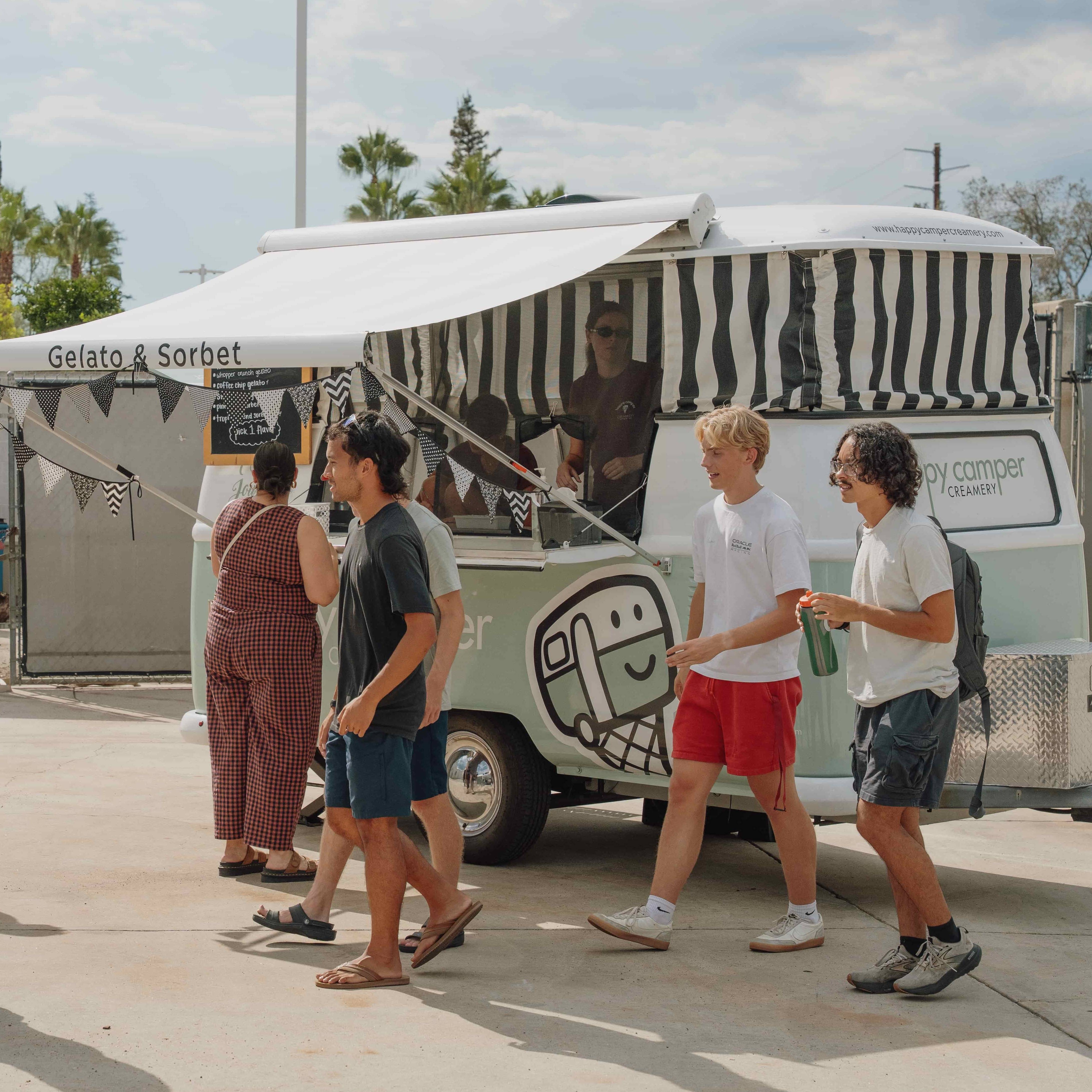 a group of people walking by a food truck