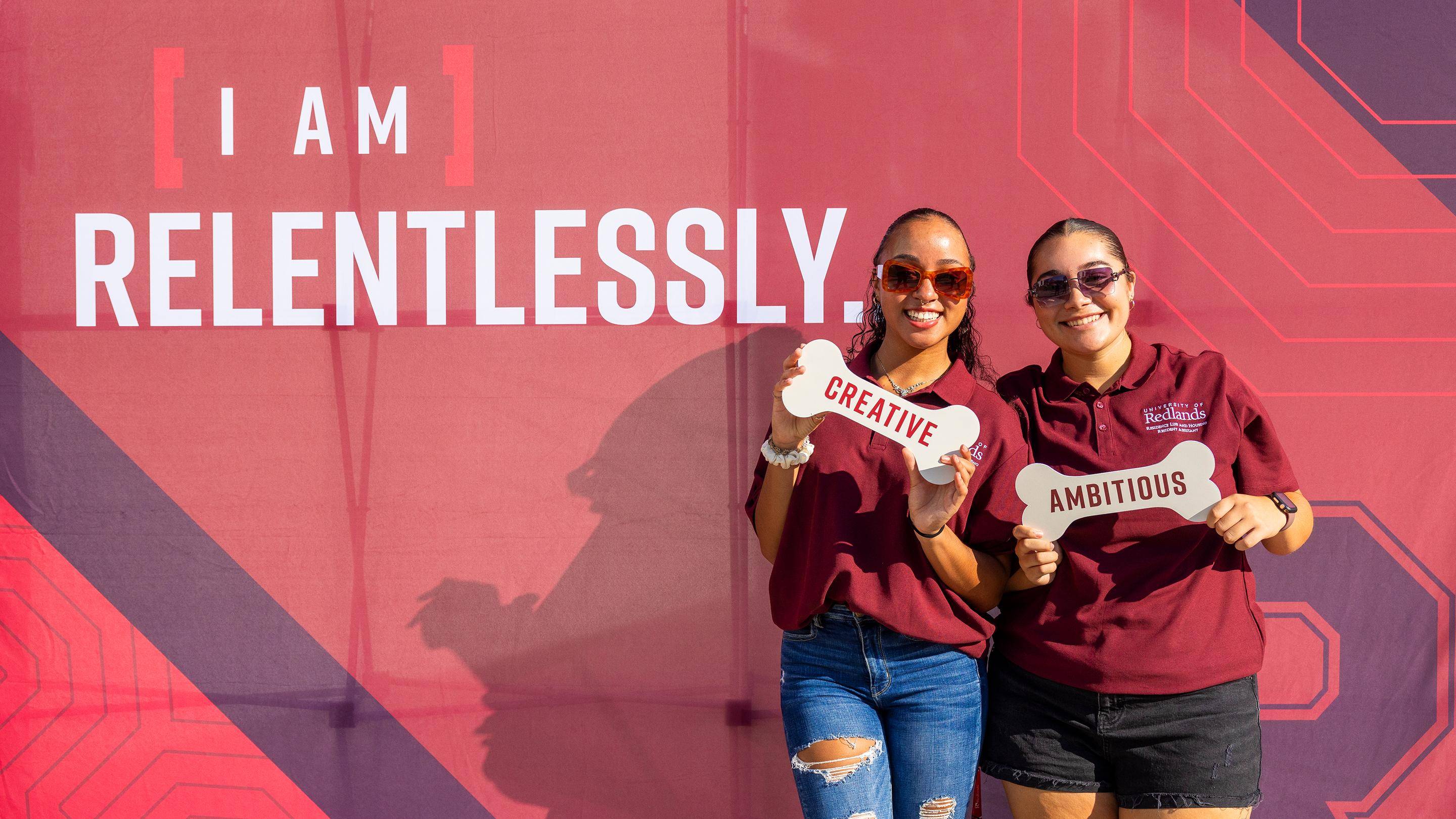 two women holding bones in front of a sign