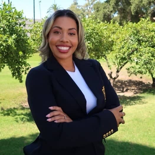 a person in a suit standing with her arms crossed