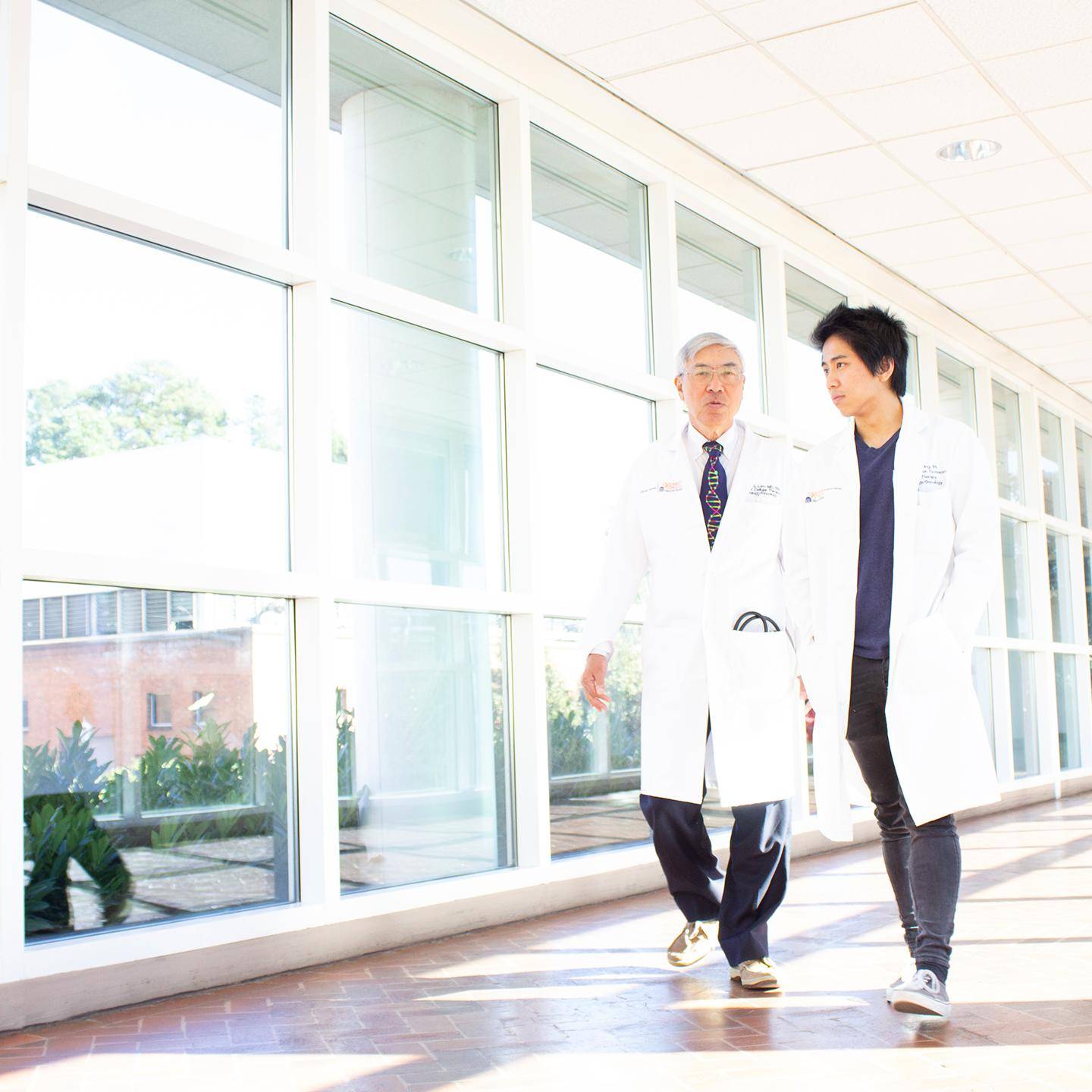 two men in white coats walking in a hallway