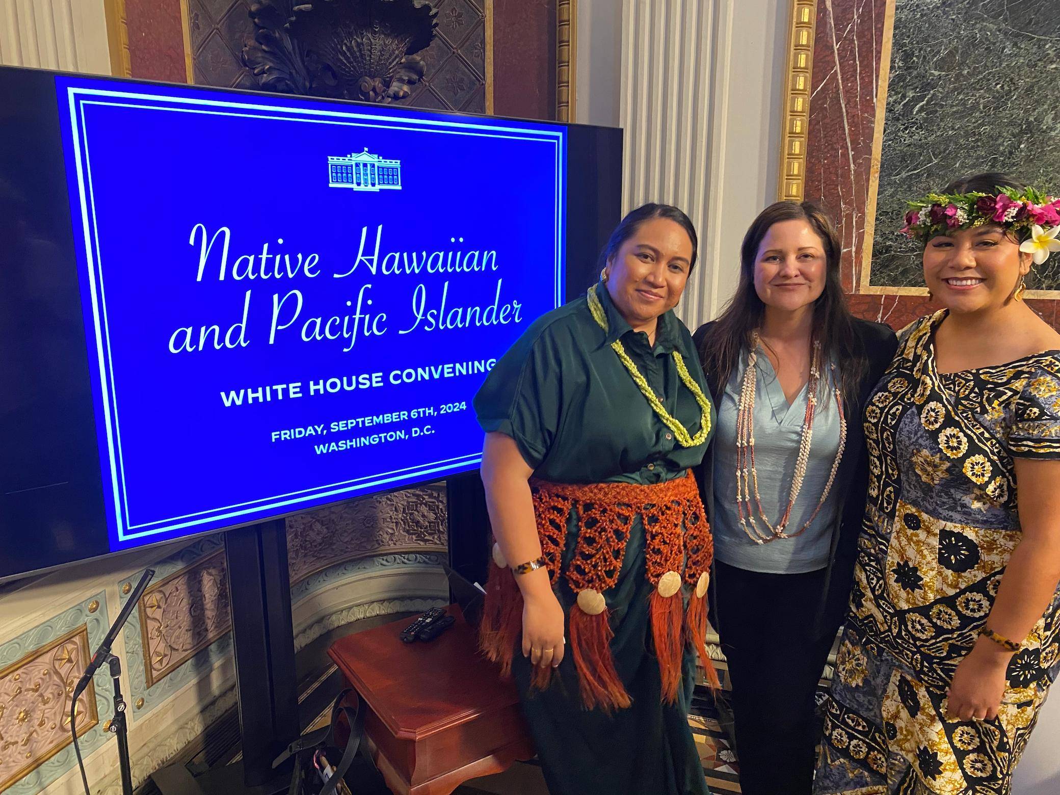 a group of women standing in front of a sign