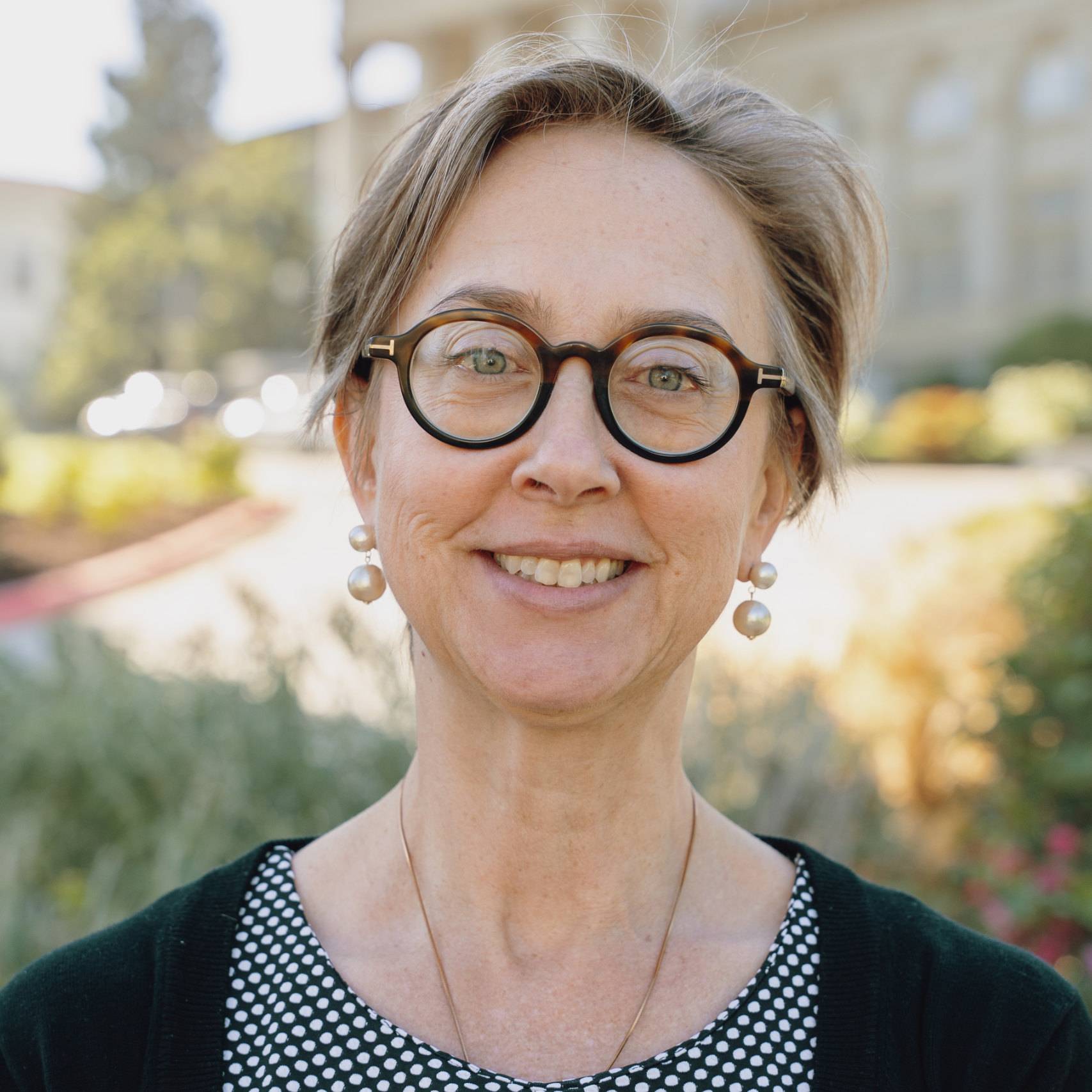 a person wearing glasses and smiling