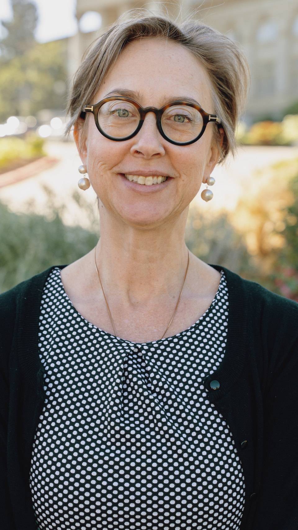 a person wearing glasses and a black and white polka dot shirt