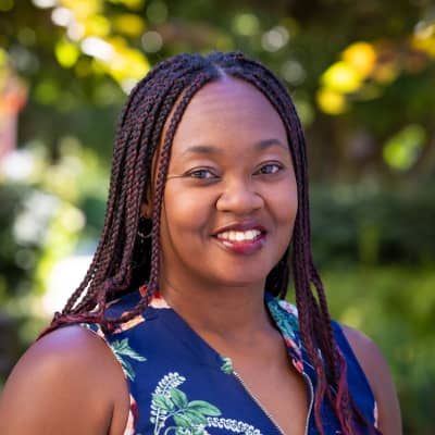 a person with braided hair smiling