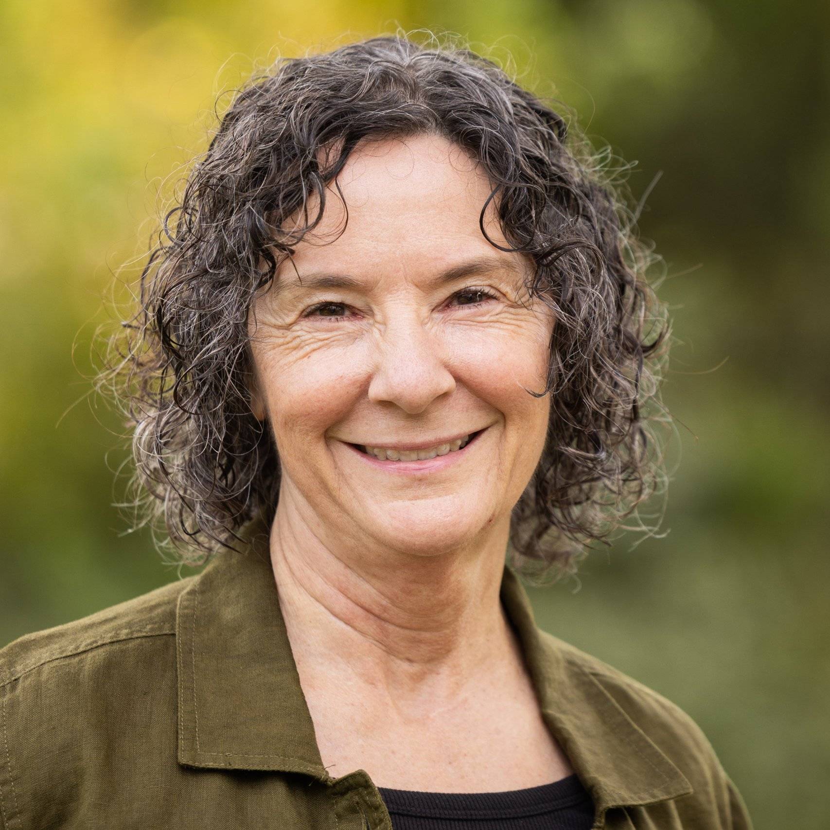 a person with curly hair smiling