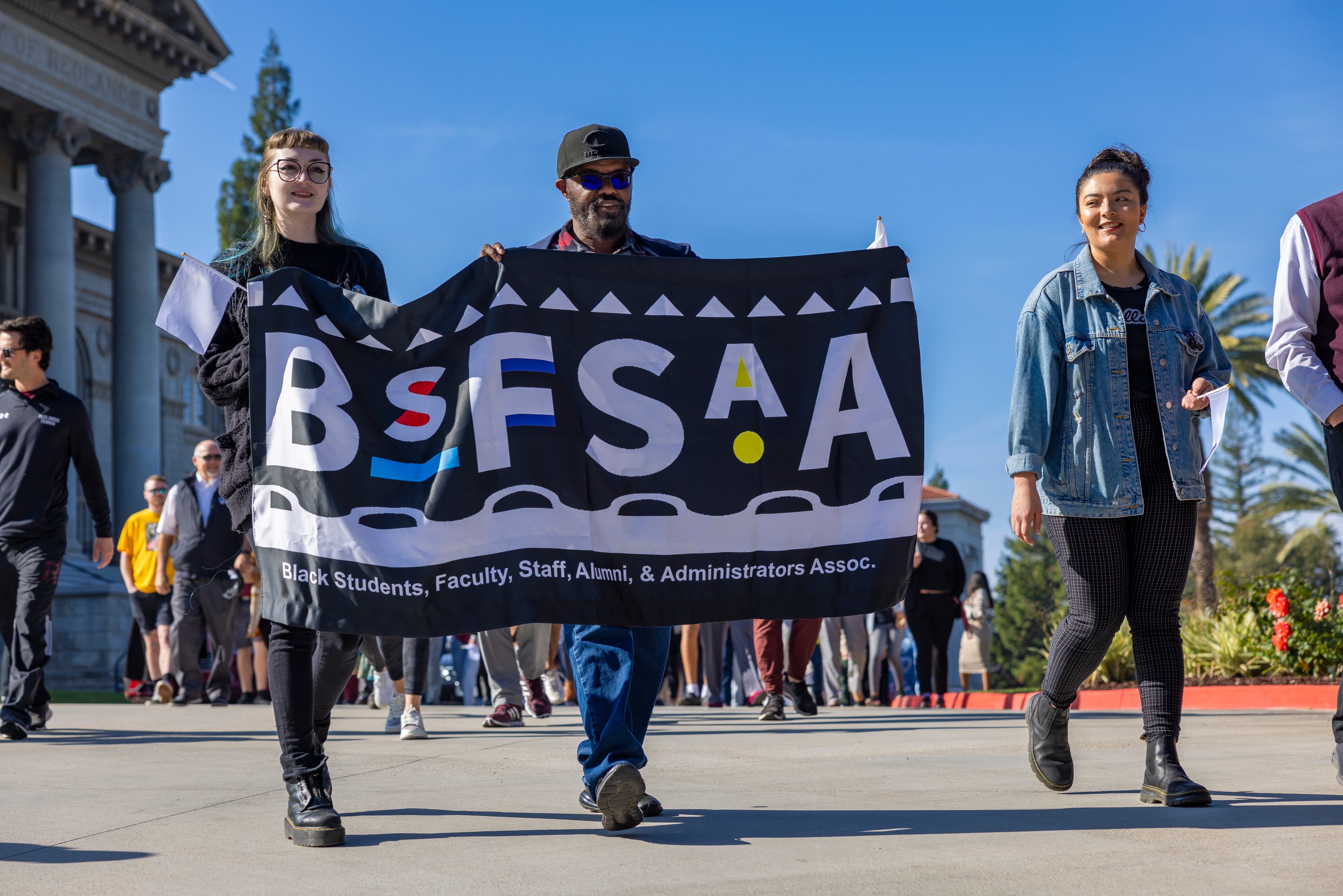 a group of people walking on a street holding a banner