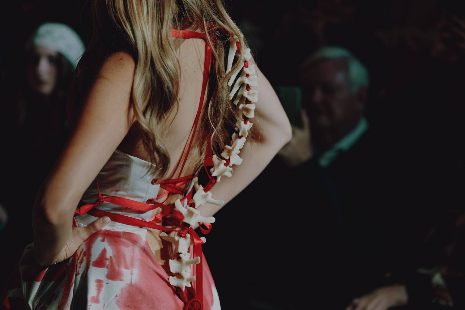 a person wearing a red and white dress with a skeleton on her back