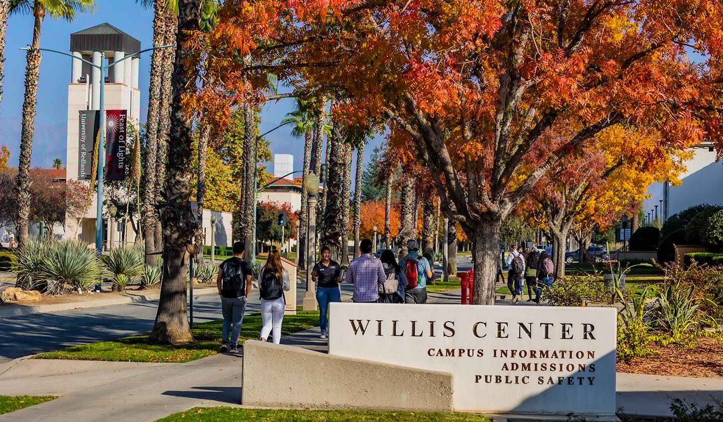 a group of people walking in front of a sign