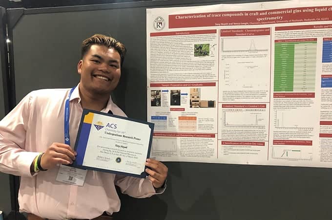 a person smiling and holding a certificate