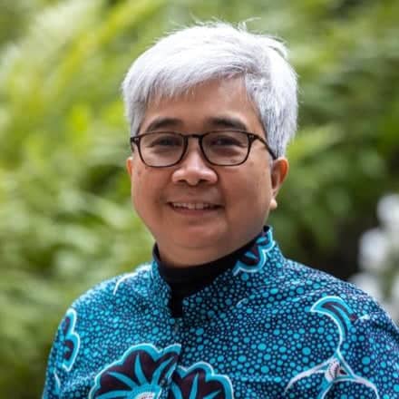 a person with glasses smiling