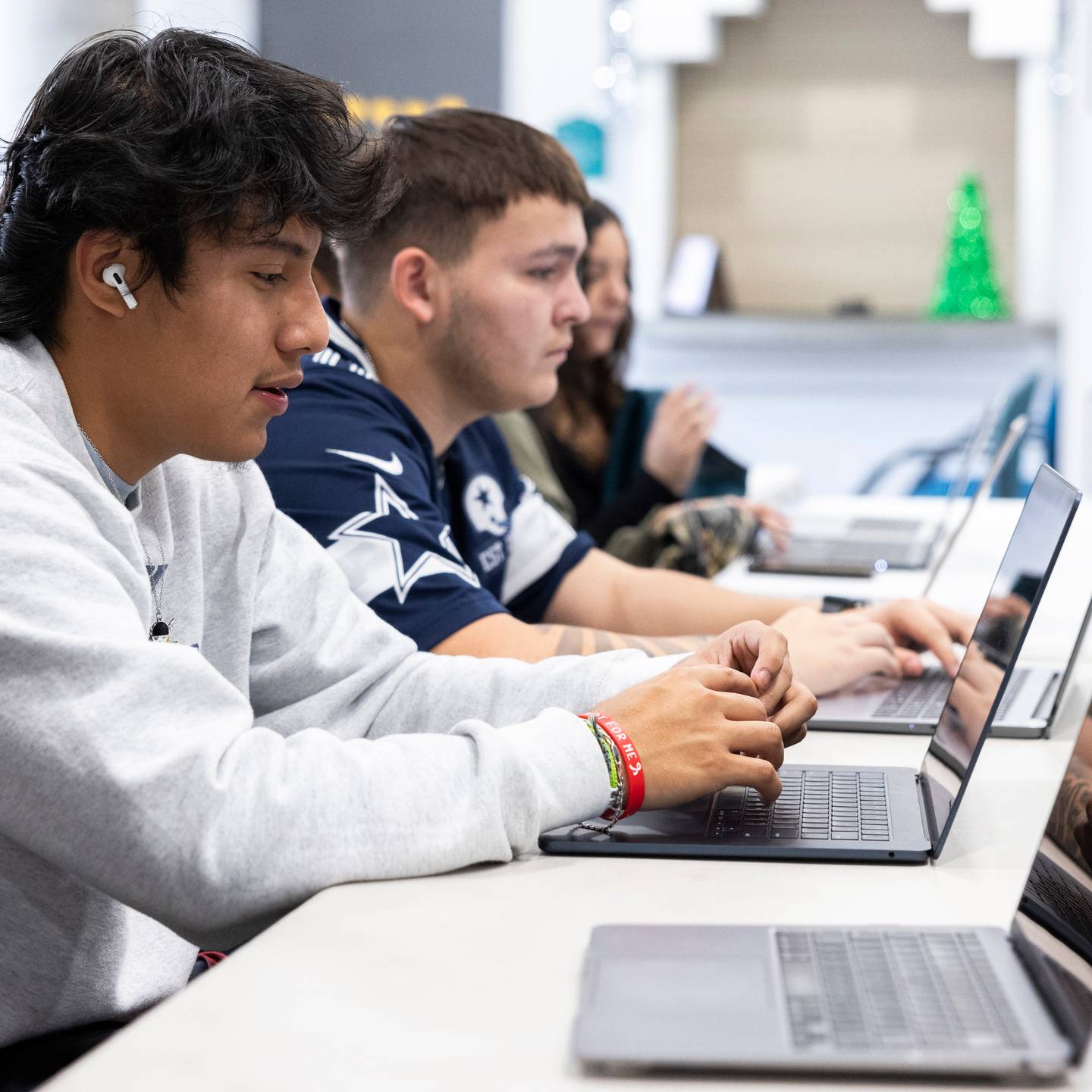 a group of people sitting at a table using laptops
