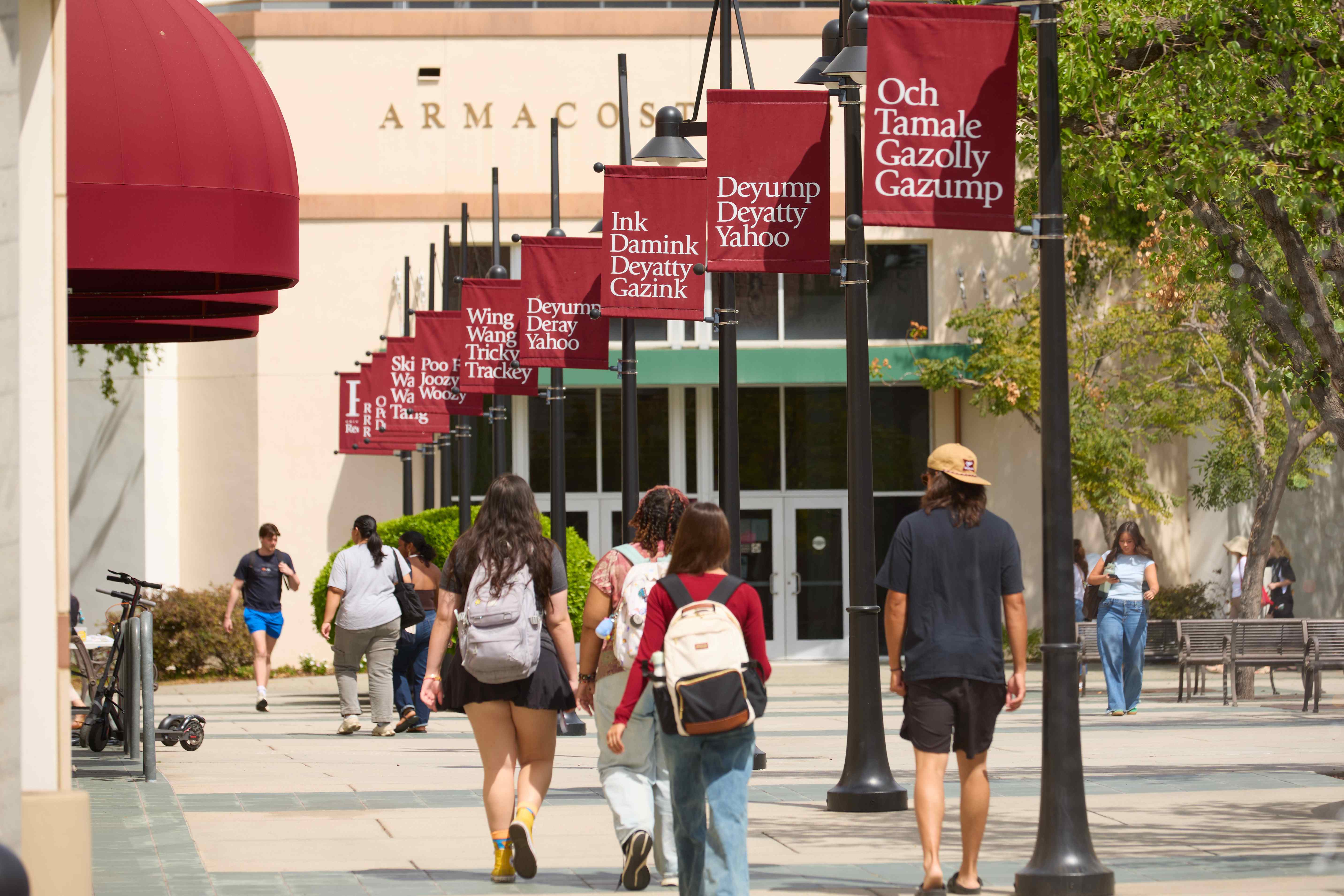 a group of people walking on a sidewalk with banners