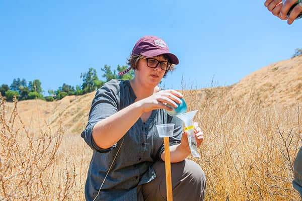 a person pouring liquid into a plastic container