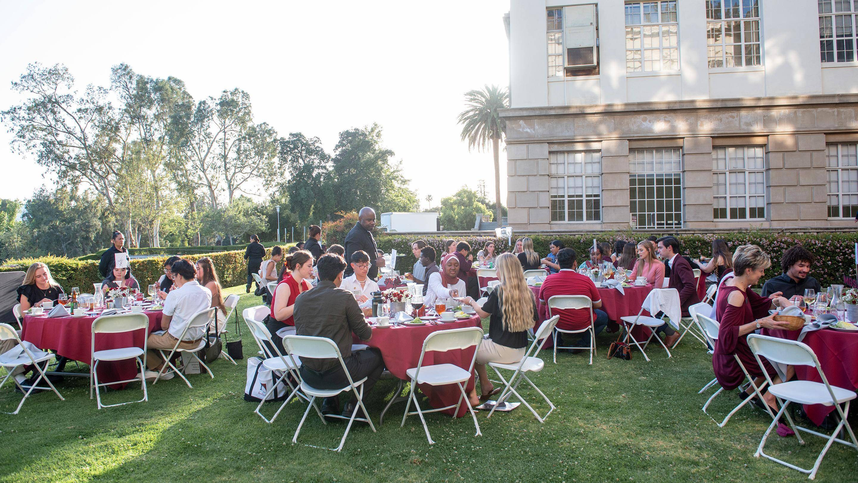 a group of people sitting around tables outside