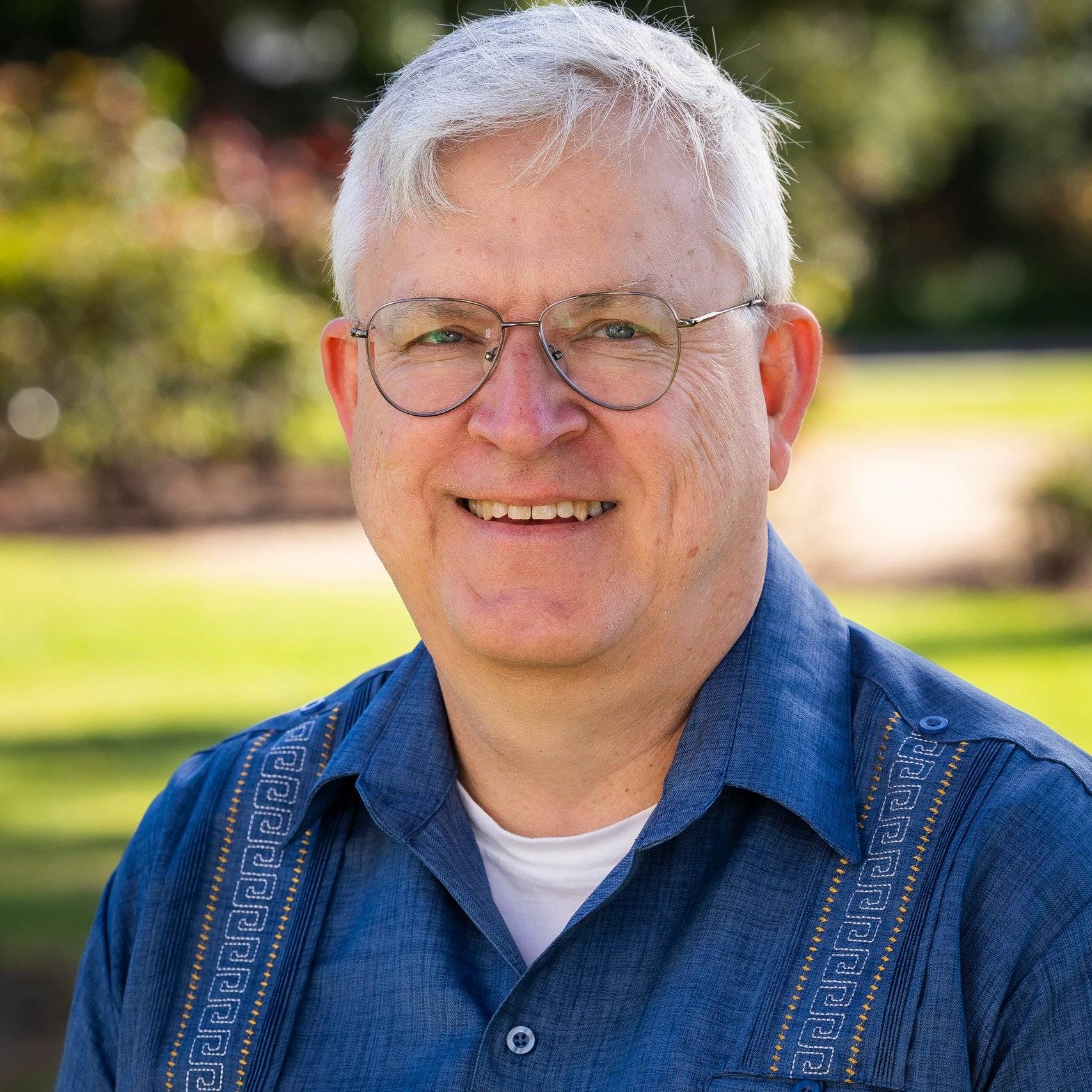 a person wearing glasses and smiling