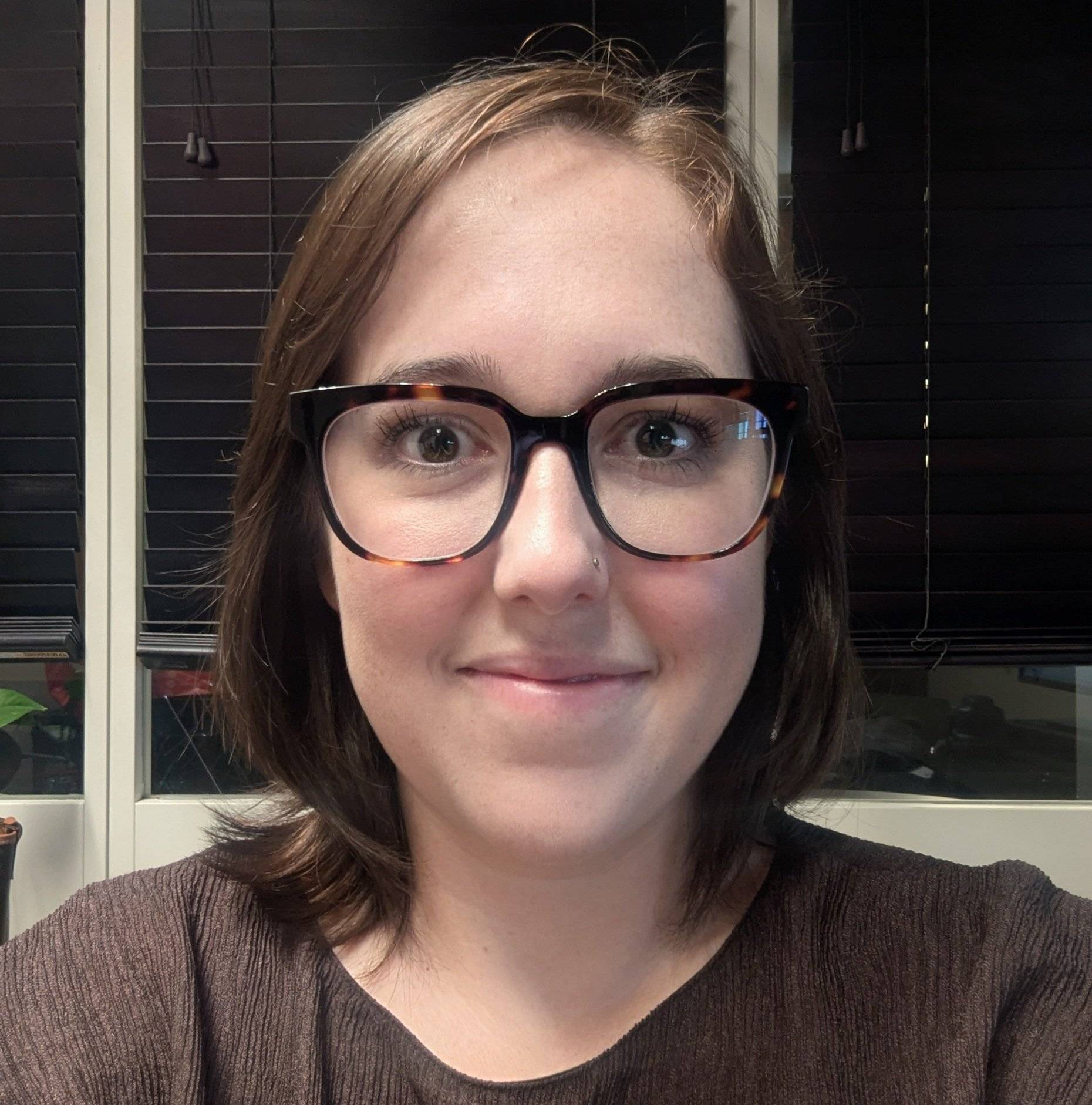 a person wearing glasses smiling