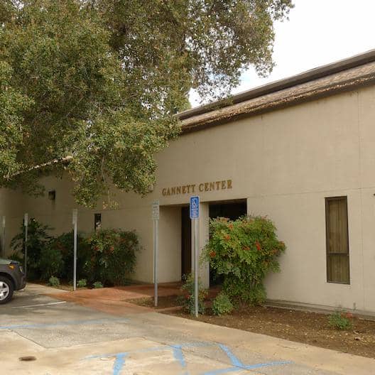 a building with trees and a parking lot