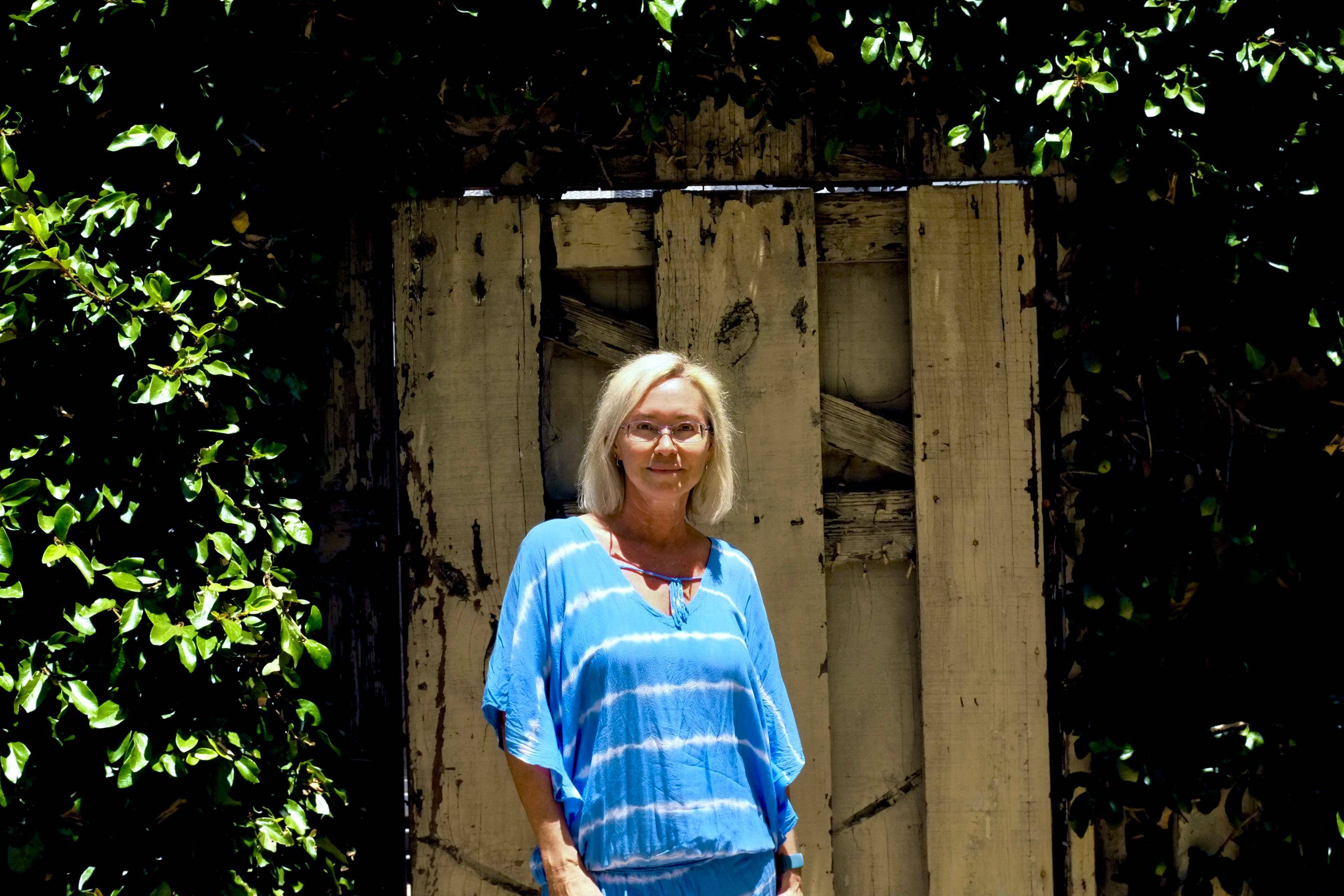 a person standing in front of a wooden fence