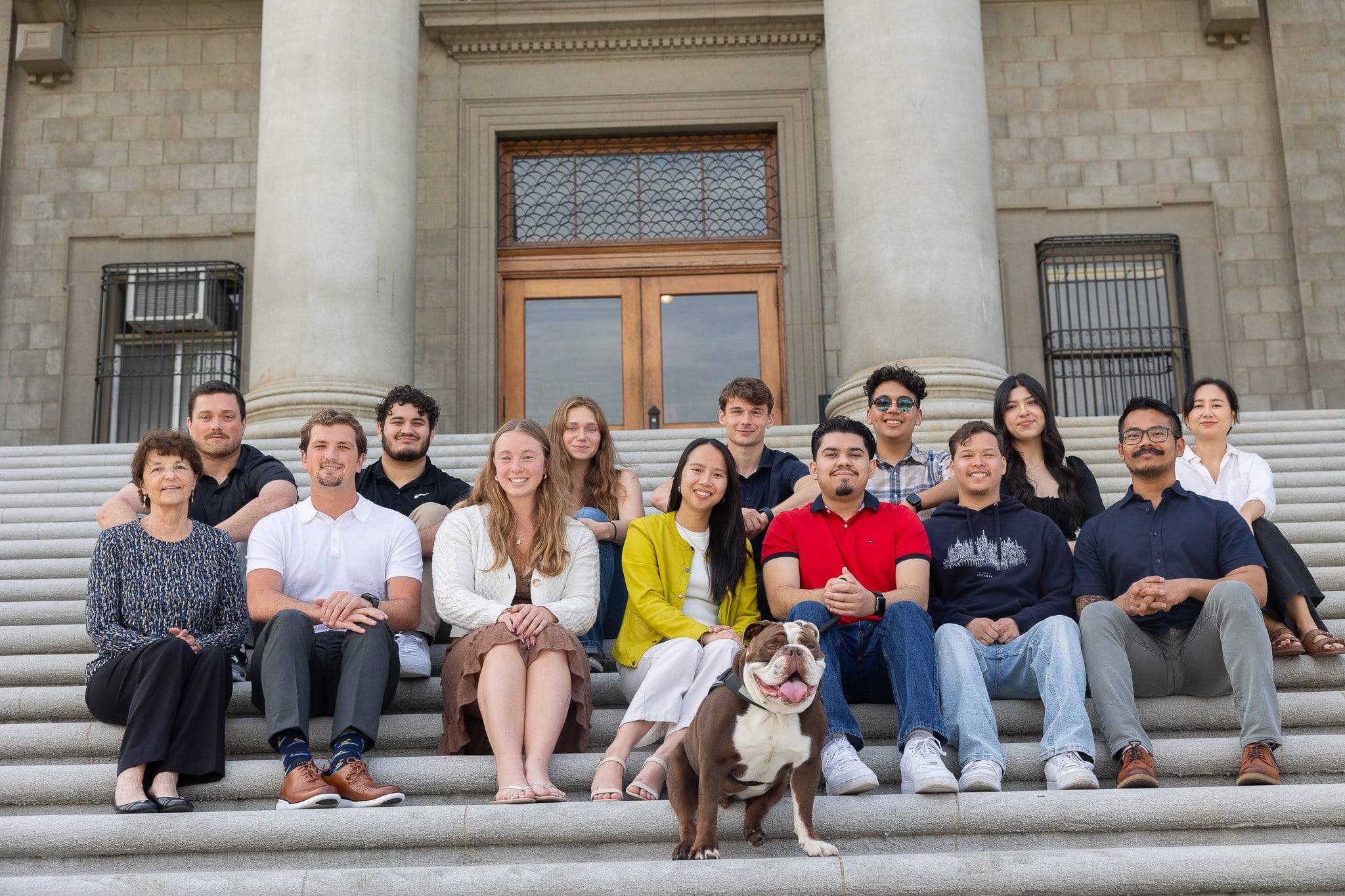 a group of people sitting on steps with a dog