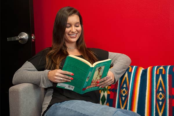 a person sitting on a couch reading a book