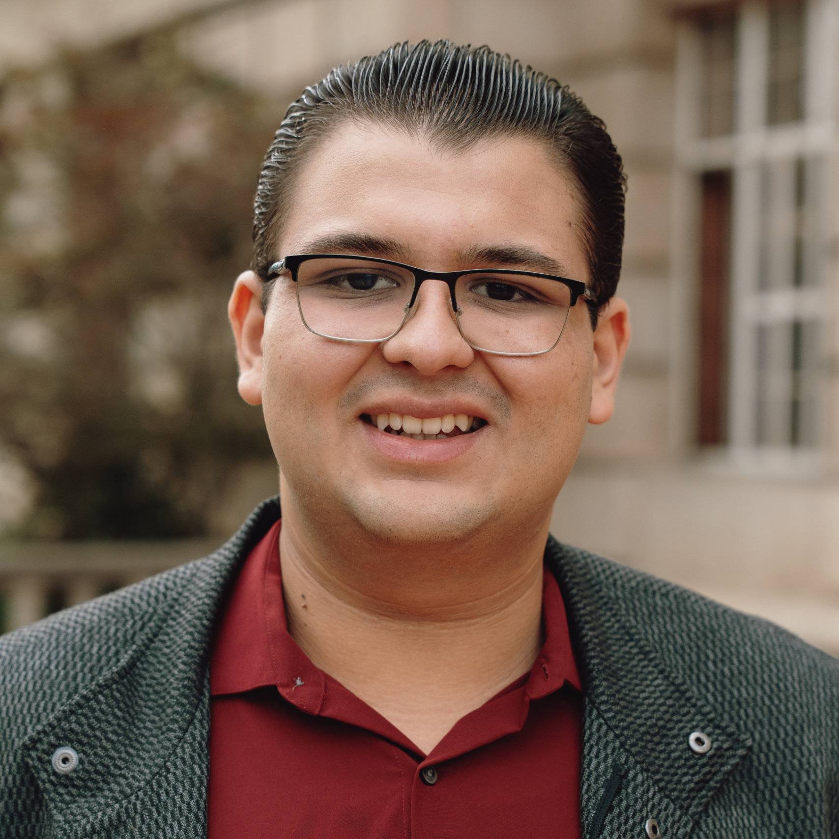 a person wearing glasses and a jacket