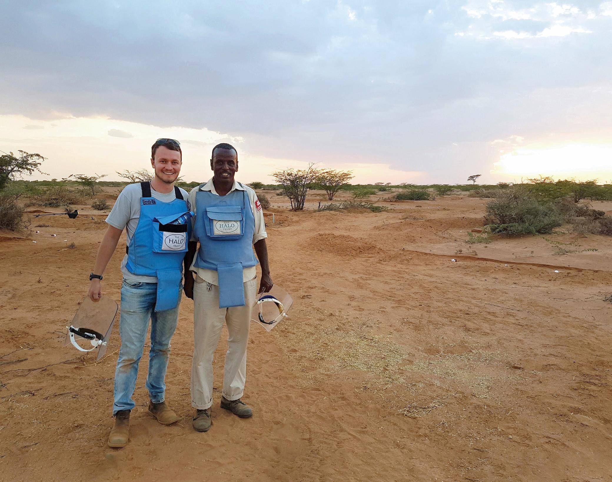 two men standing in a dirt field
