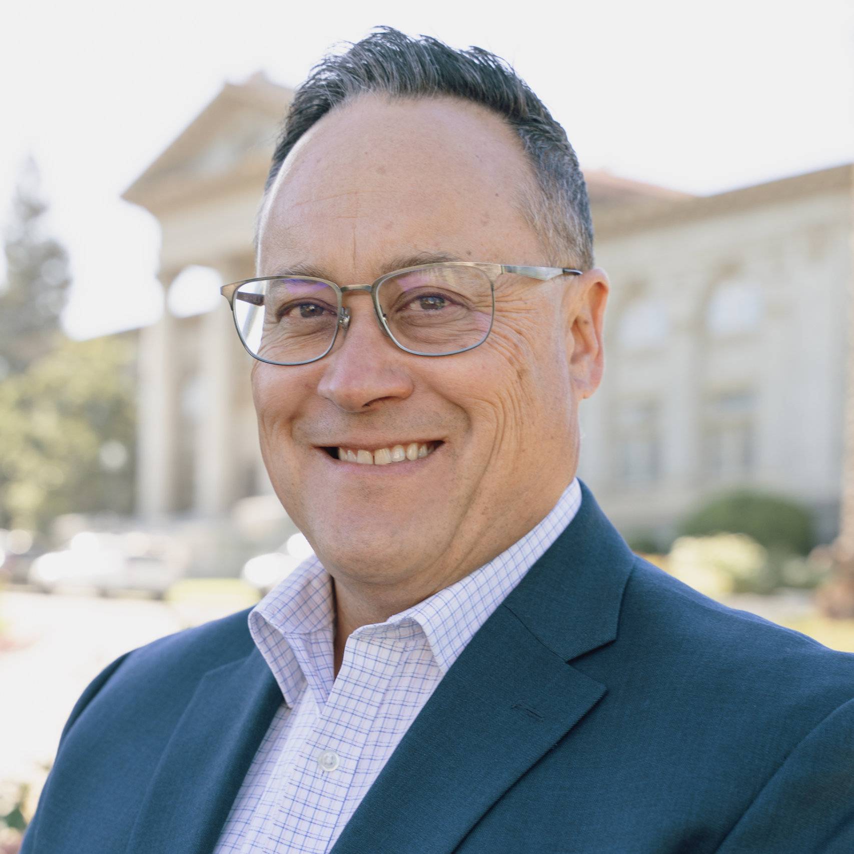 a person wearing glasses and a suit
