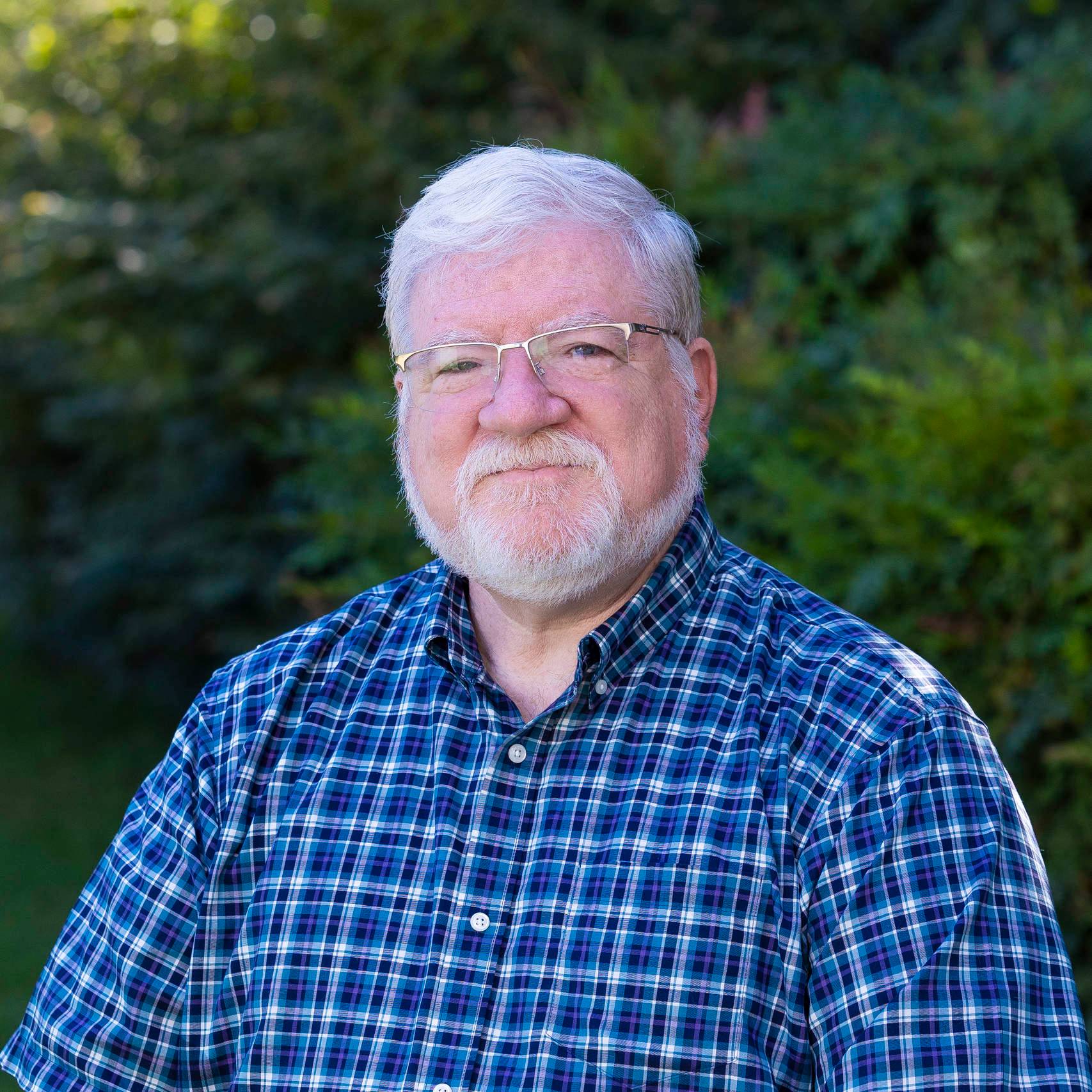 a person with white hair and beard wearing glasses