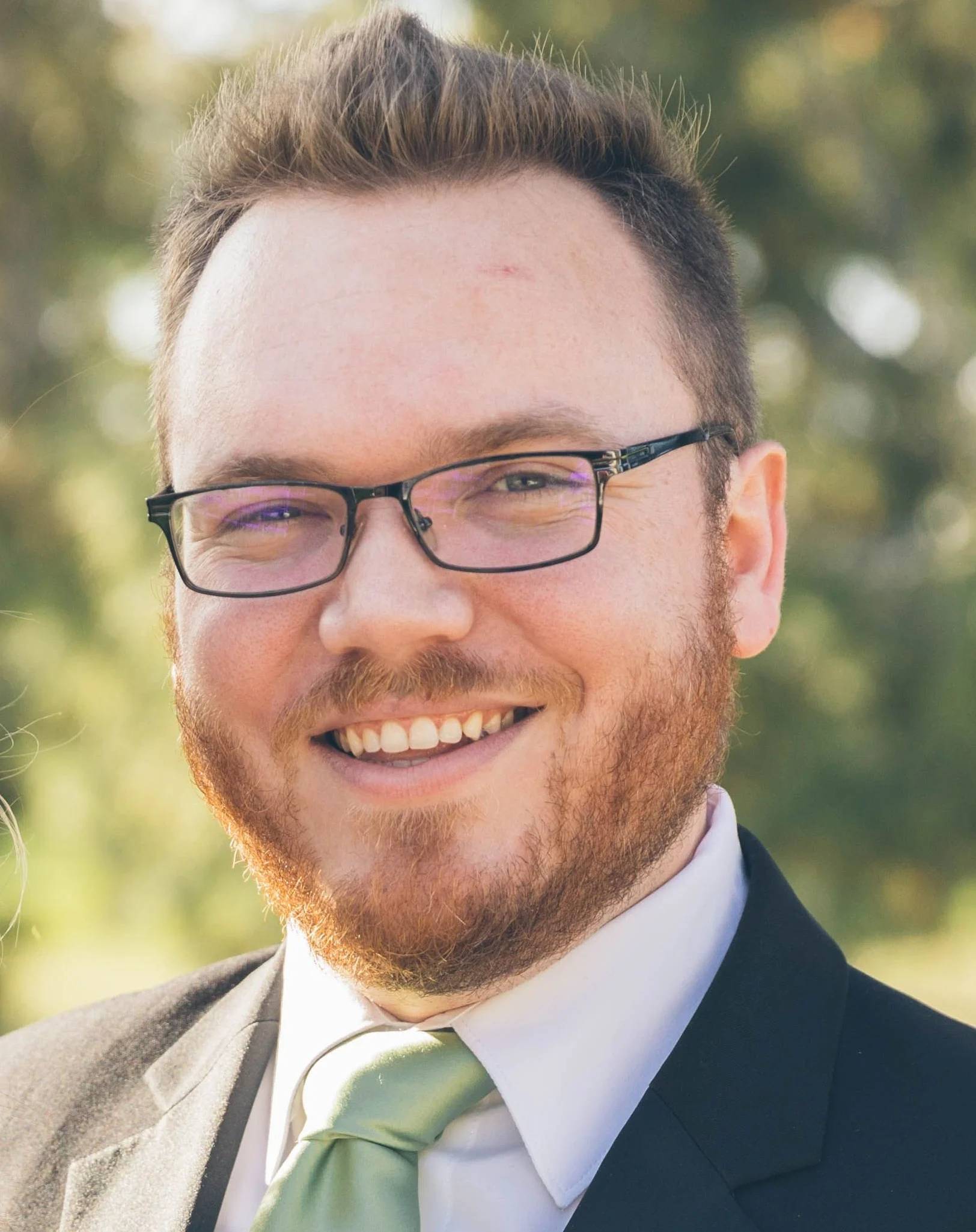 a person wearing glasses and a suit