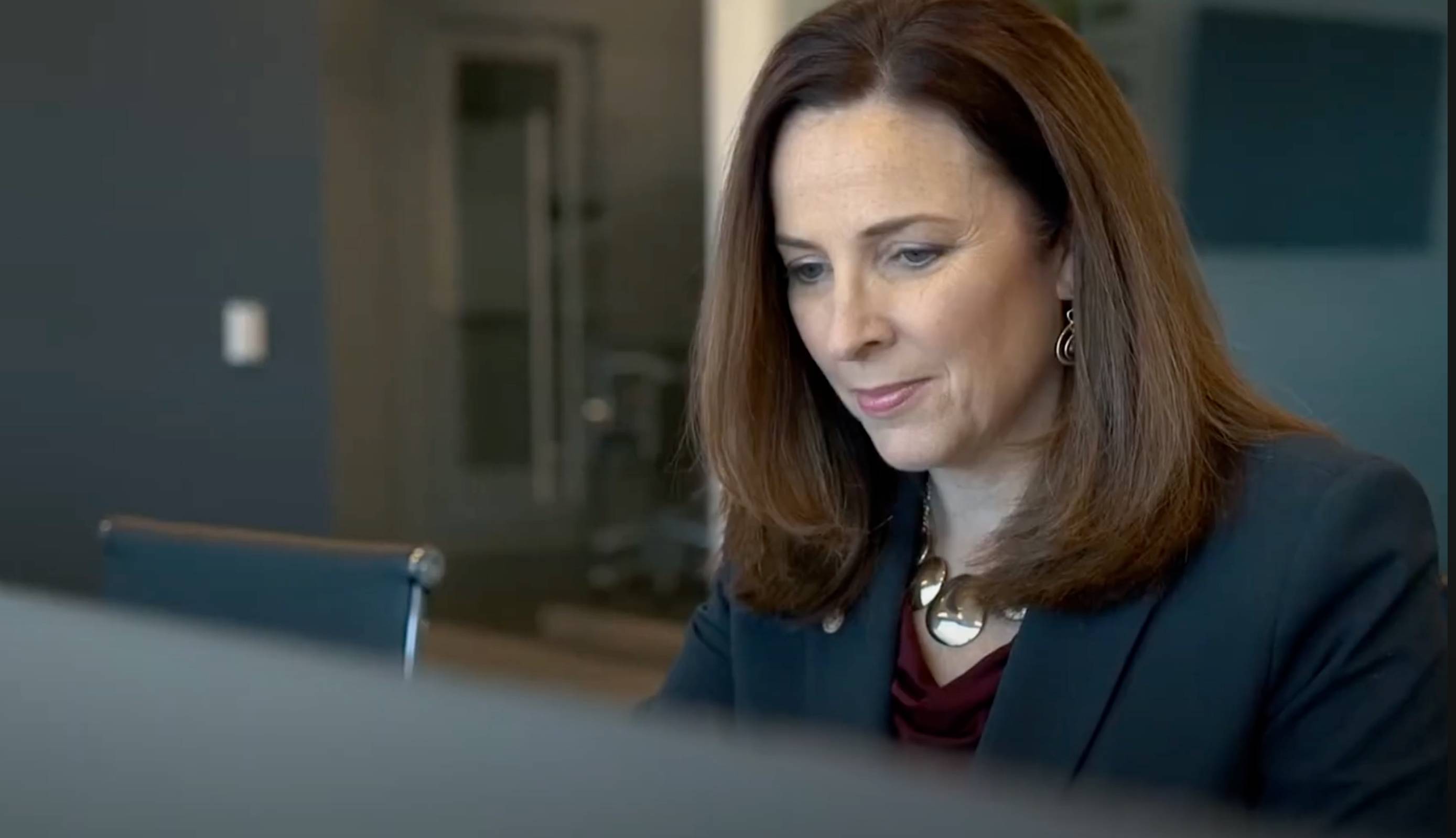 a person looking down at a computer screen