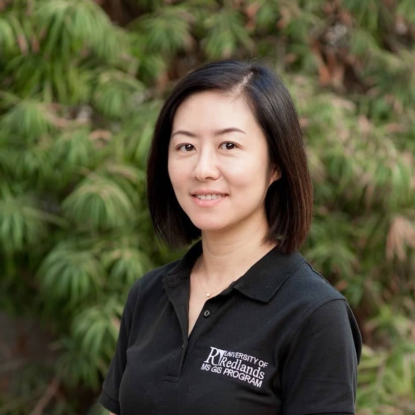 a person smiling in front of a tree