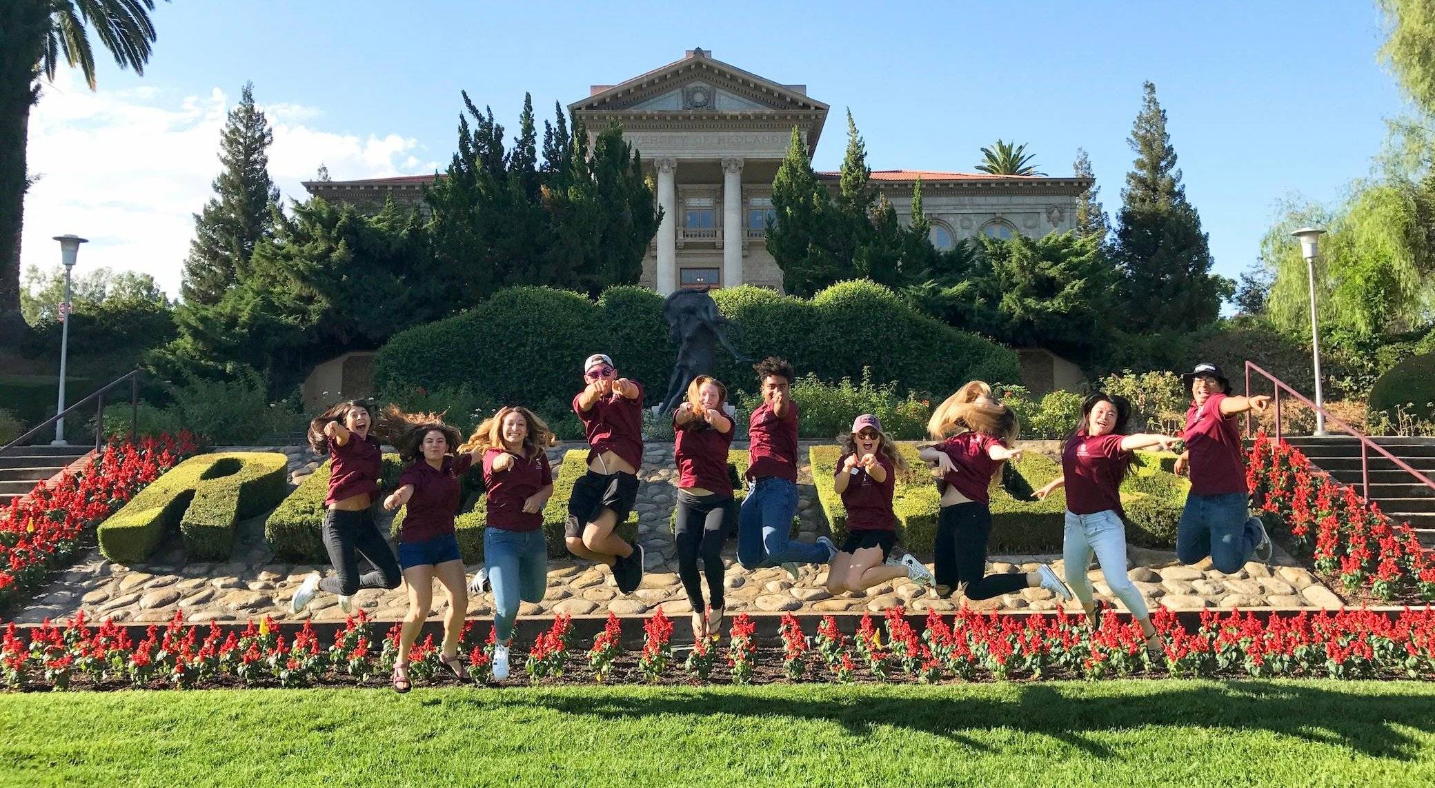 a group of people jumping in front of a building