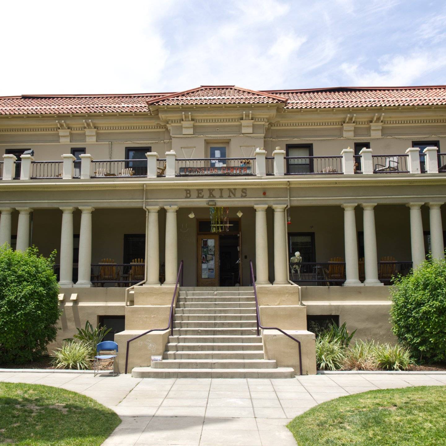 a building with columns and a lawn